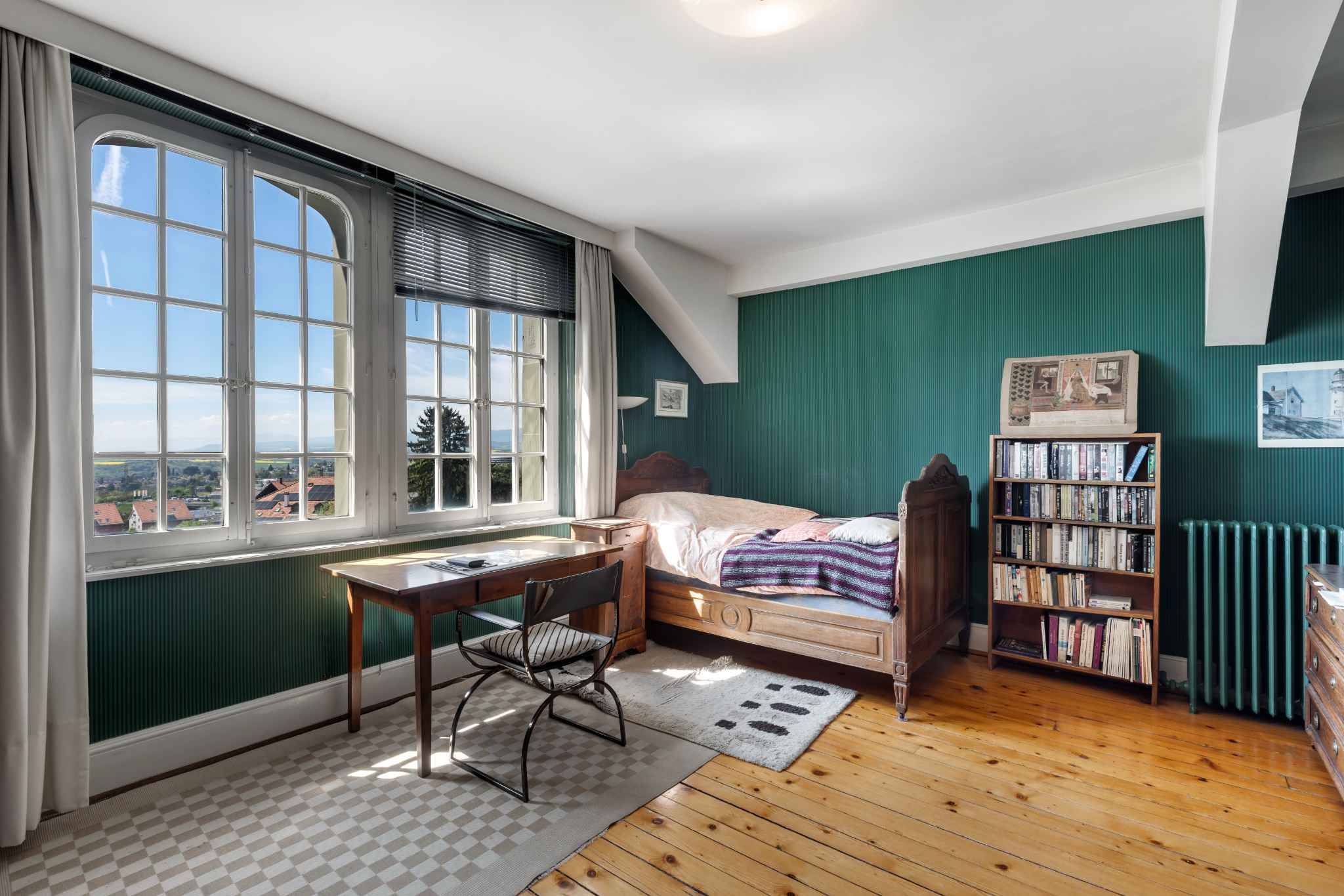 Helles Schlafzimmer mit Schreibtisch und Ausblick