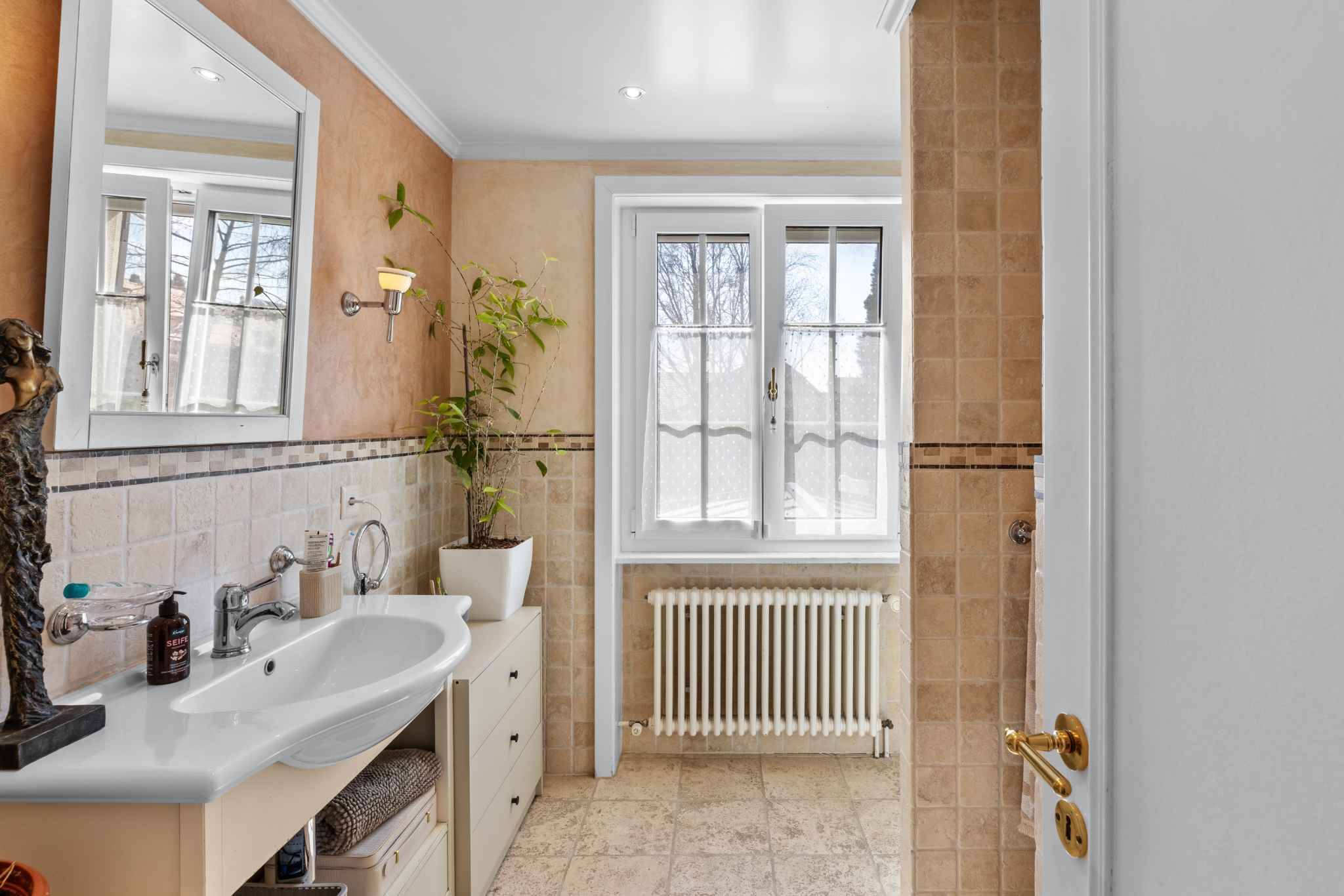 Helles Badezimmer mit Naturstein und Fenster