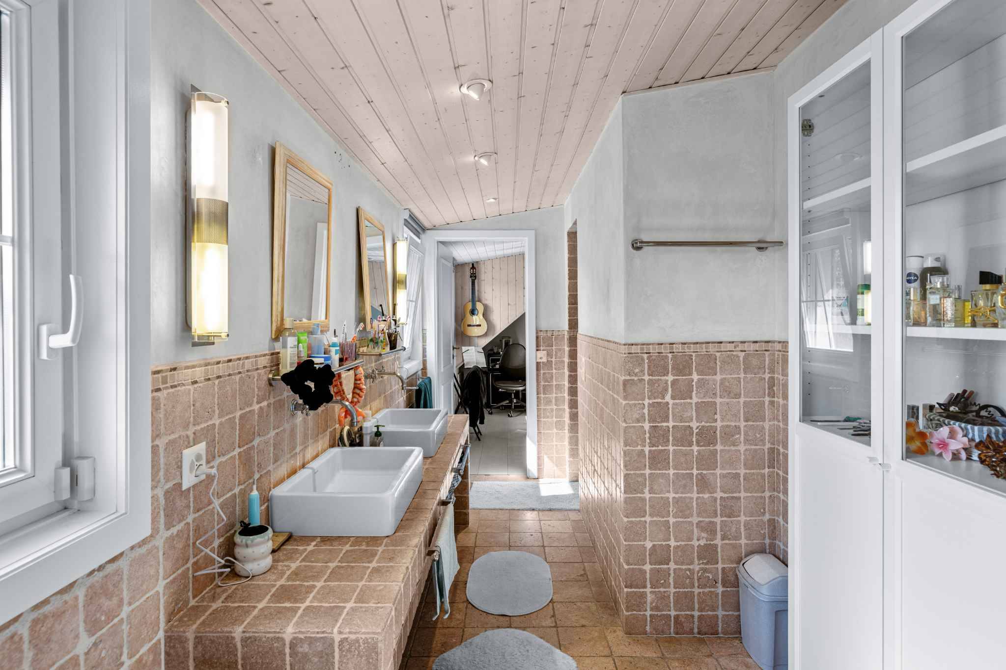Badezimmer mit Doppelwaschbecken und Natursteinoptik