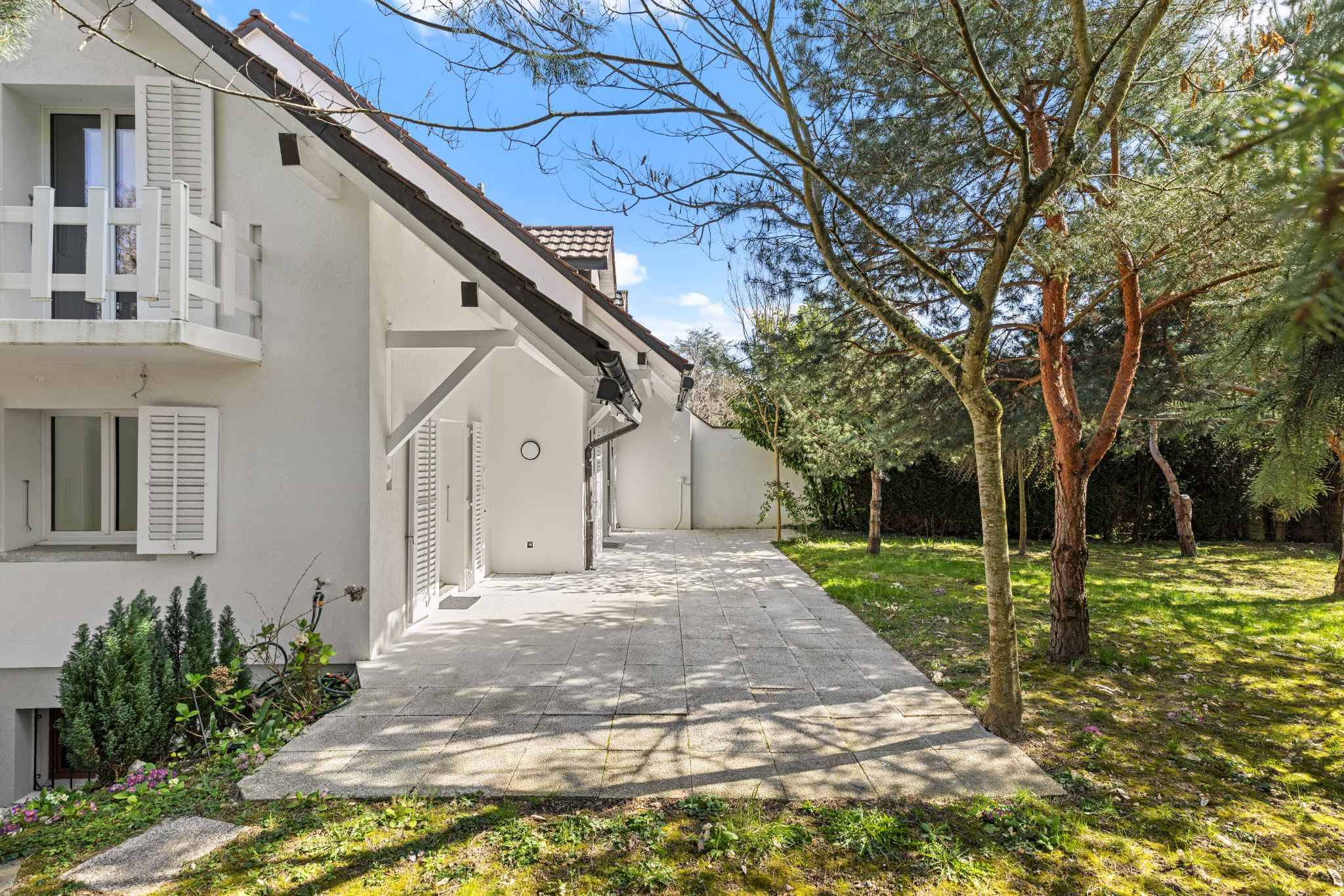 Weiße Hausfassade mit Garten und Terrasse