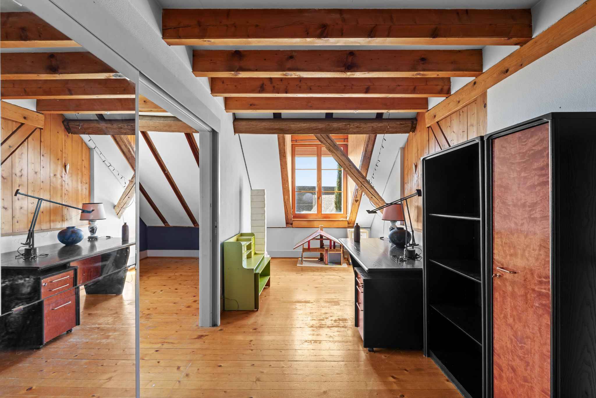 Dachgeschossraum mit sichtbaren Holzbalken