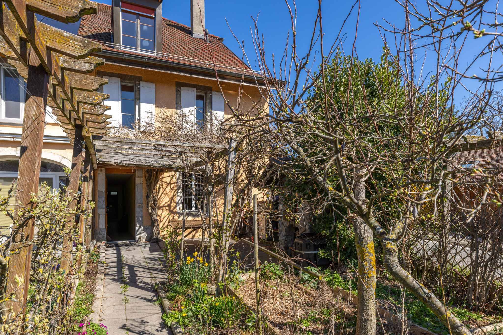 Hausfassade mit Garten und Laubengang