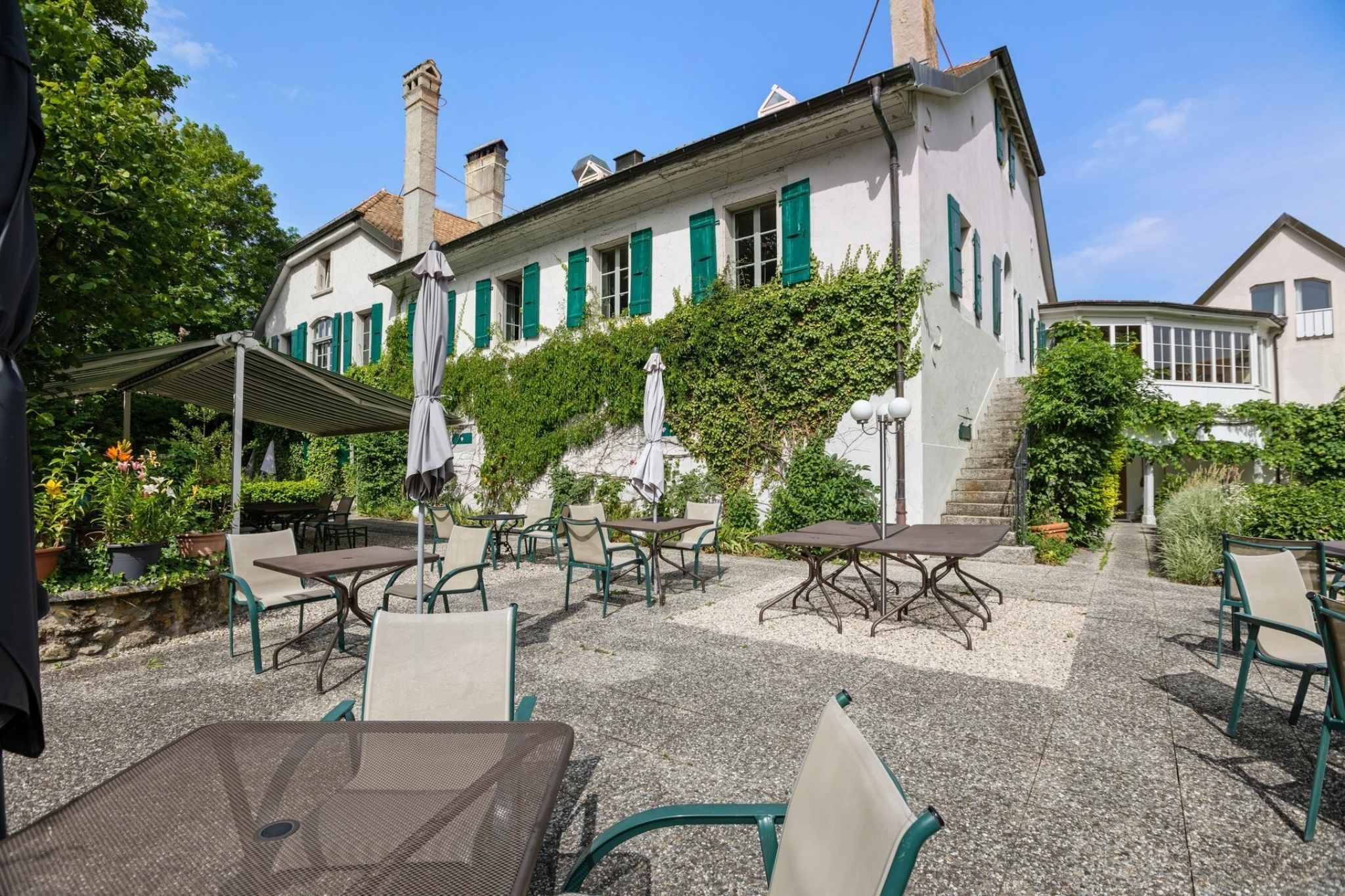 Außenansicht eines historischen Gebäudes mit Innenhof-Terrasse