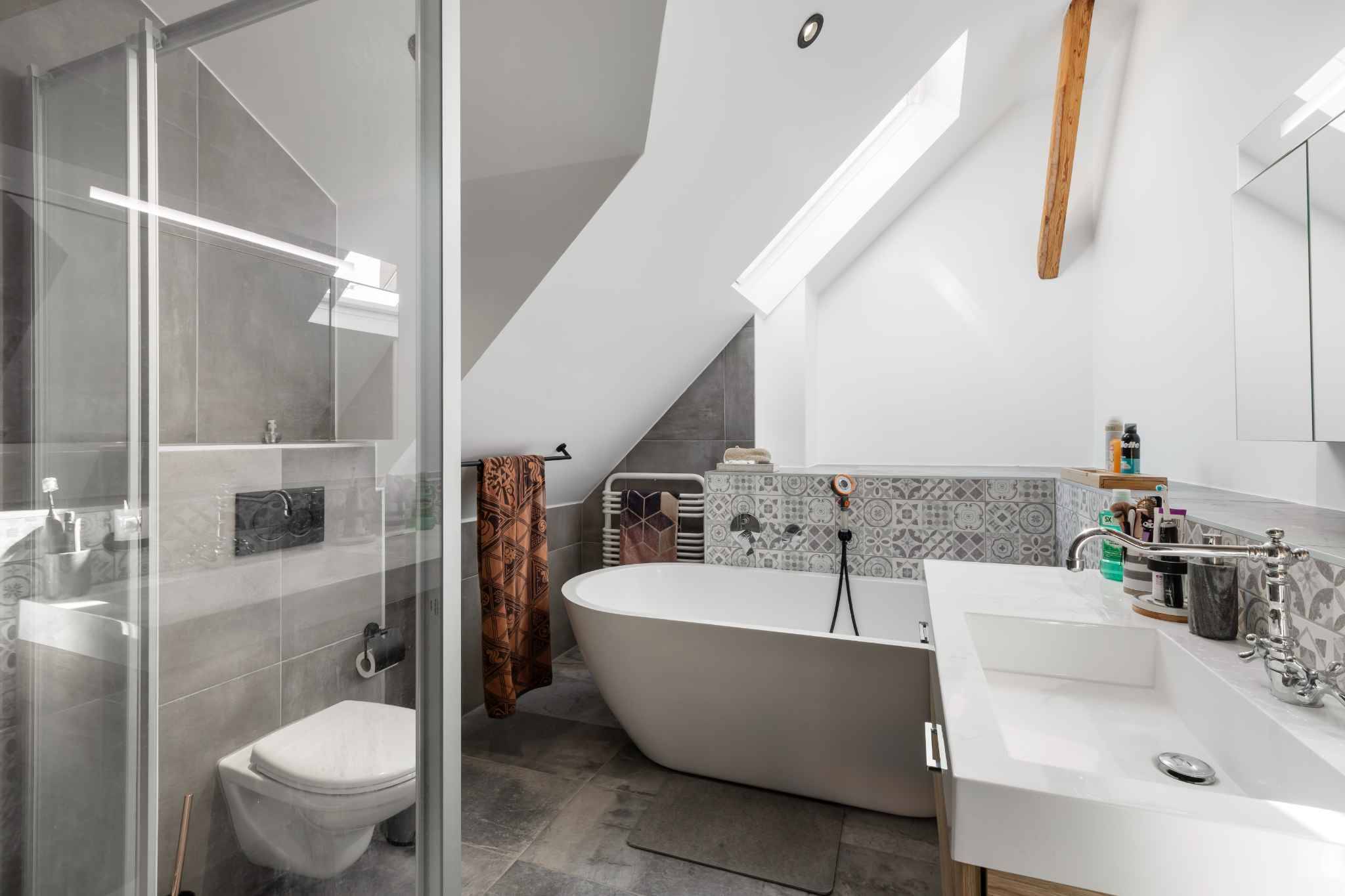 Modernes Badezimmer unterm Dach mit Badewanne und Dusche