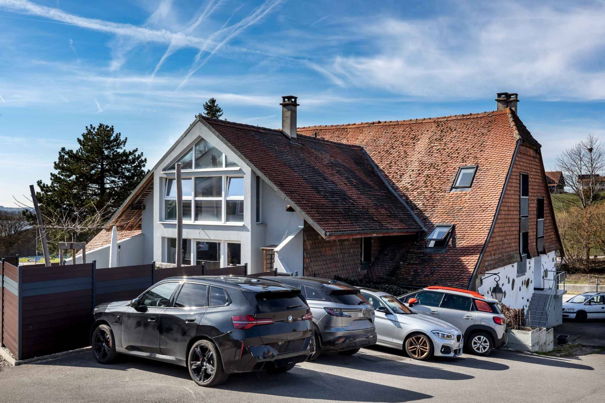 Außenansicht eines Wohnhauses mit geparkten Autos