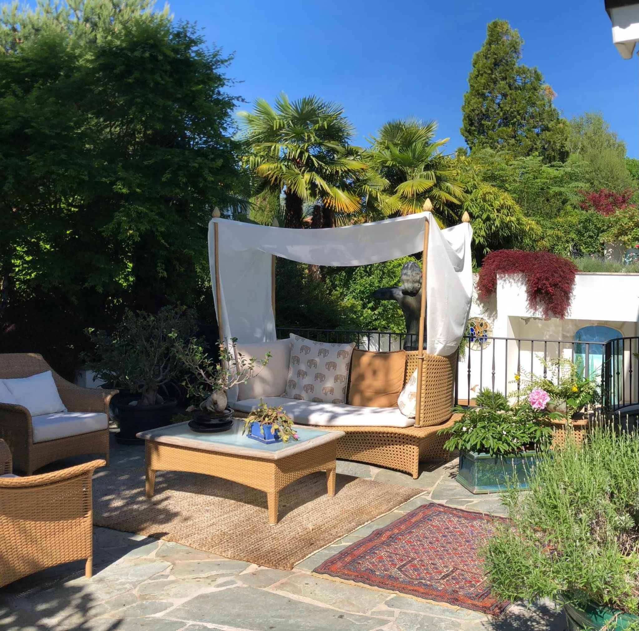 Üppige Gartenterrasse mit Lounge-Möbeln