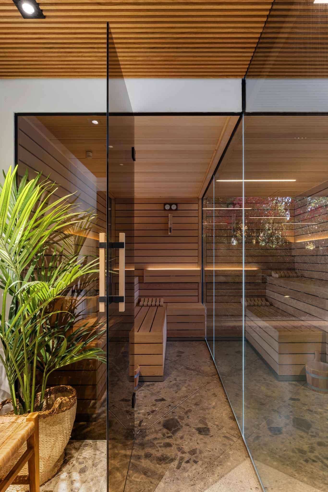 Innenansicht einer holzverkleideten Sauna mit Glasfront