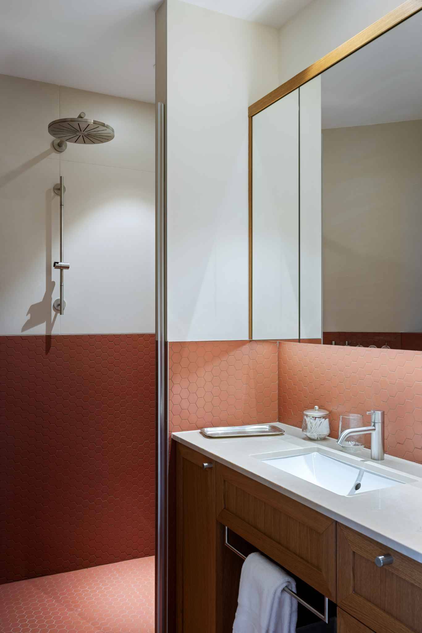 Modernes Badezimmer mit rosafarbenen Fliesen und Holzmöbel