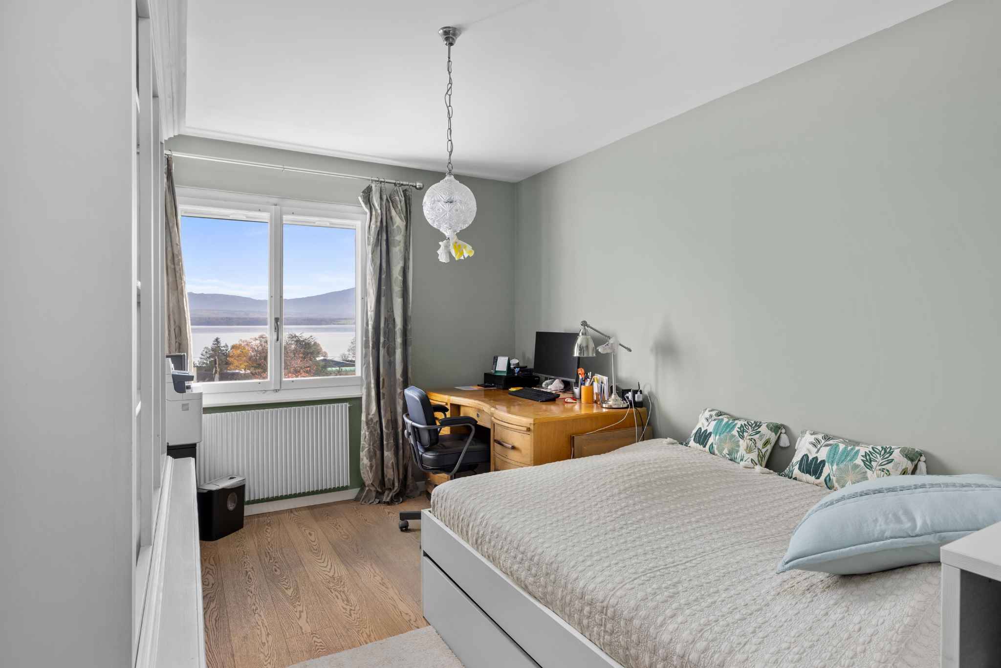 Helles Schlafzimmer mit Arbeitsplatz und Ausblick