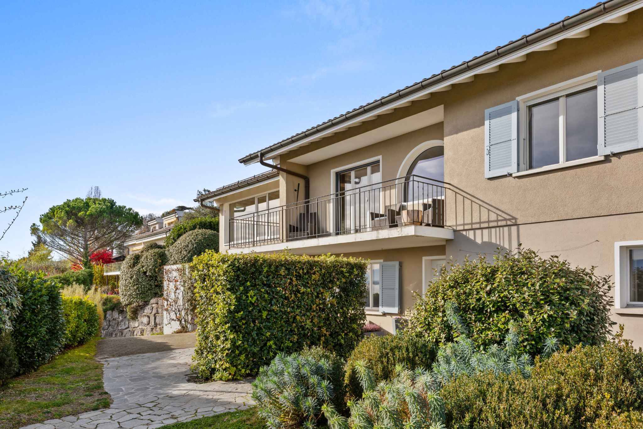Mediterrane Hausfassade mit Balkon und Garten