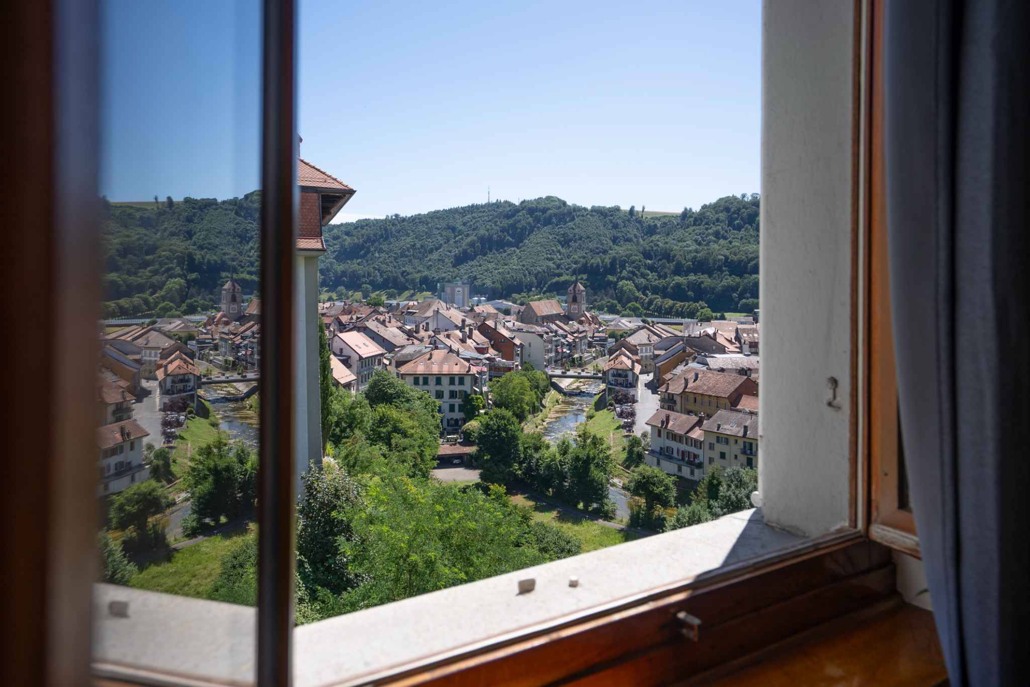 Blick aus dem Fenster auf eine Stadt mit Fluss und Hügeln