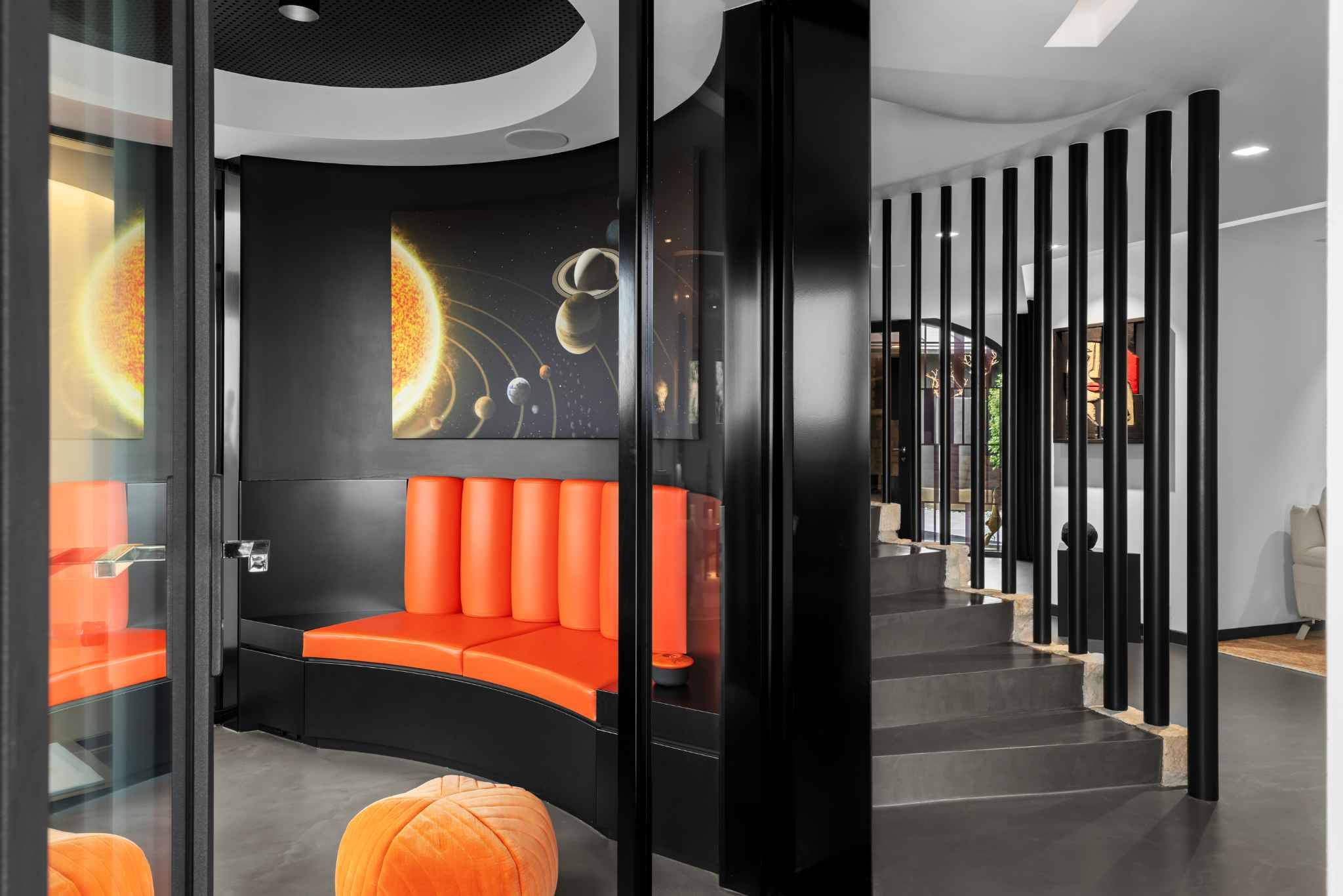 Modernes, futuristisch gestaltetes Interieur mit orangefarbener Sitznische und geschwungener Treppe
