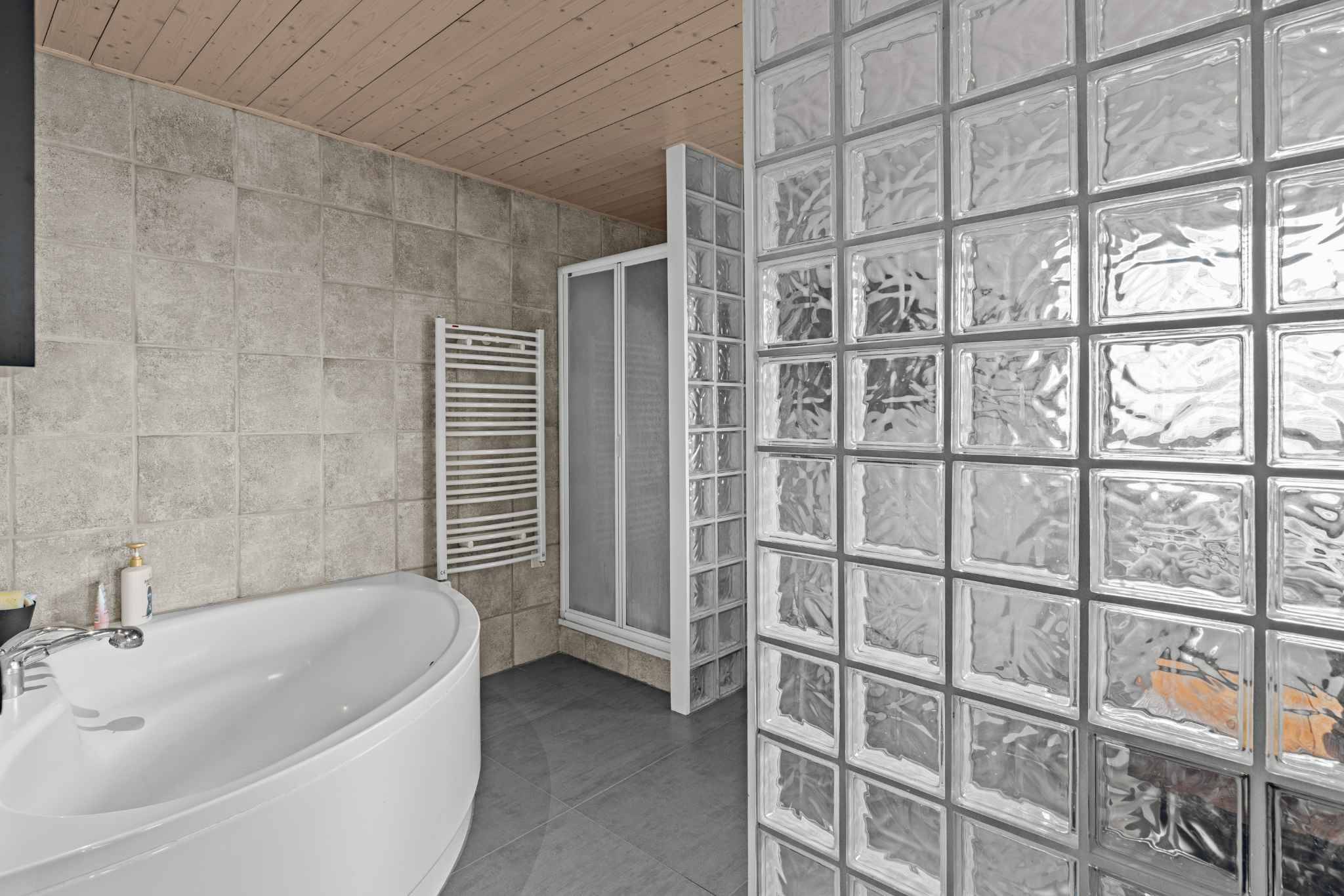 Modernes Badezimmer mit Glasbausteinwand und Badewanne