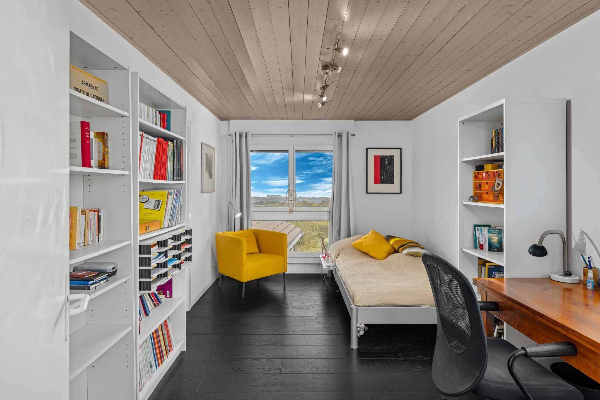 Helles Arbeits- und Schlafzimmer mit Bibliotheksregalen