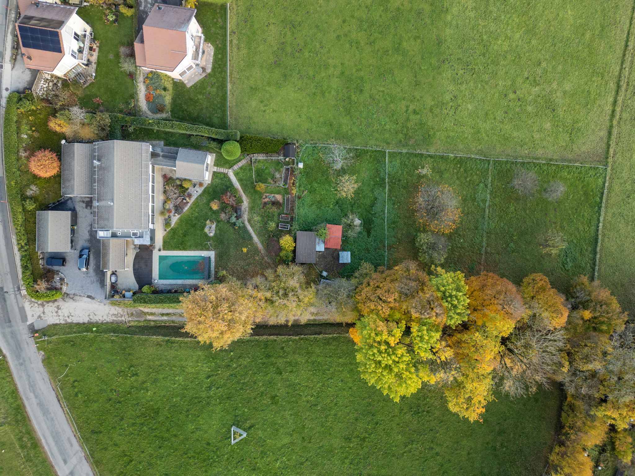 Luftaufnahme eines Wohngrundstücks mit Haus, Garten und Pool