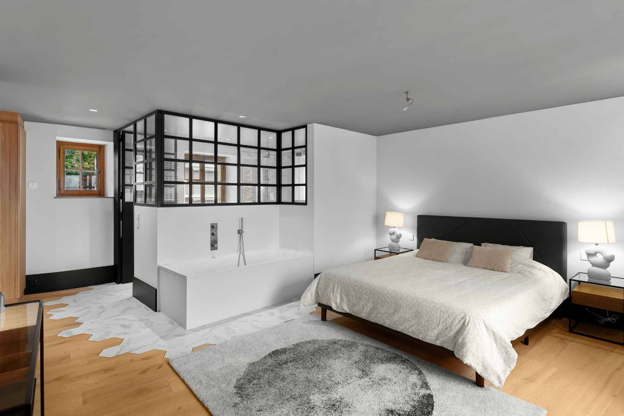 Modernes Schlafzimmer mit Glasabtrennung und freistehender Badewanne