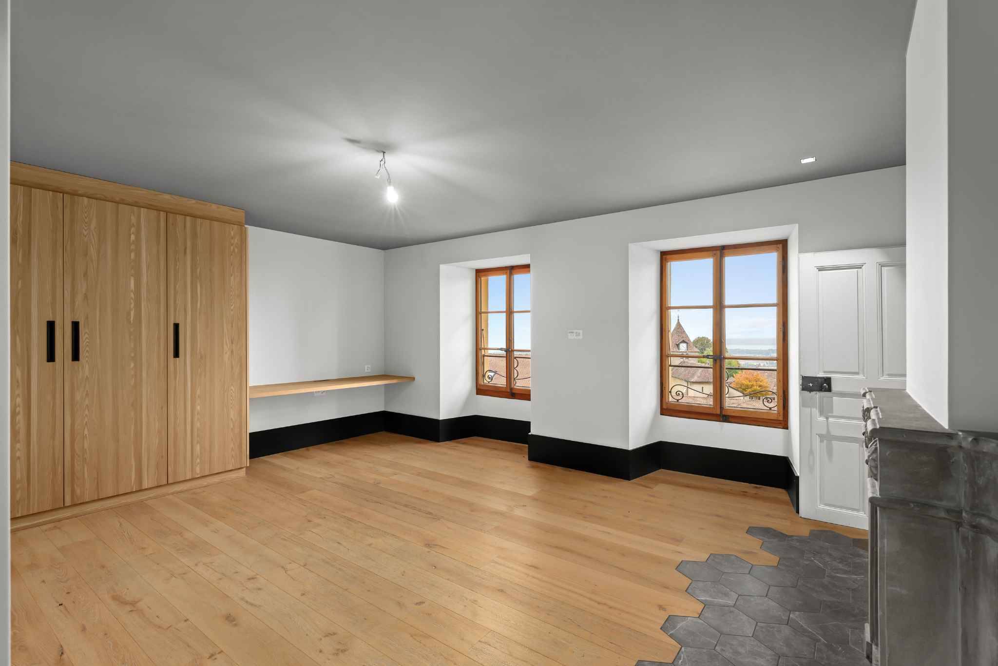 Helles Zimmer mit Holzschrank und Blick nach draußen