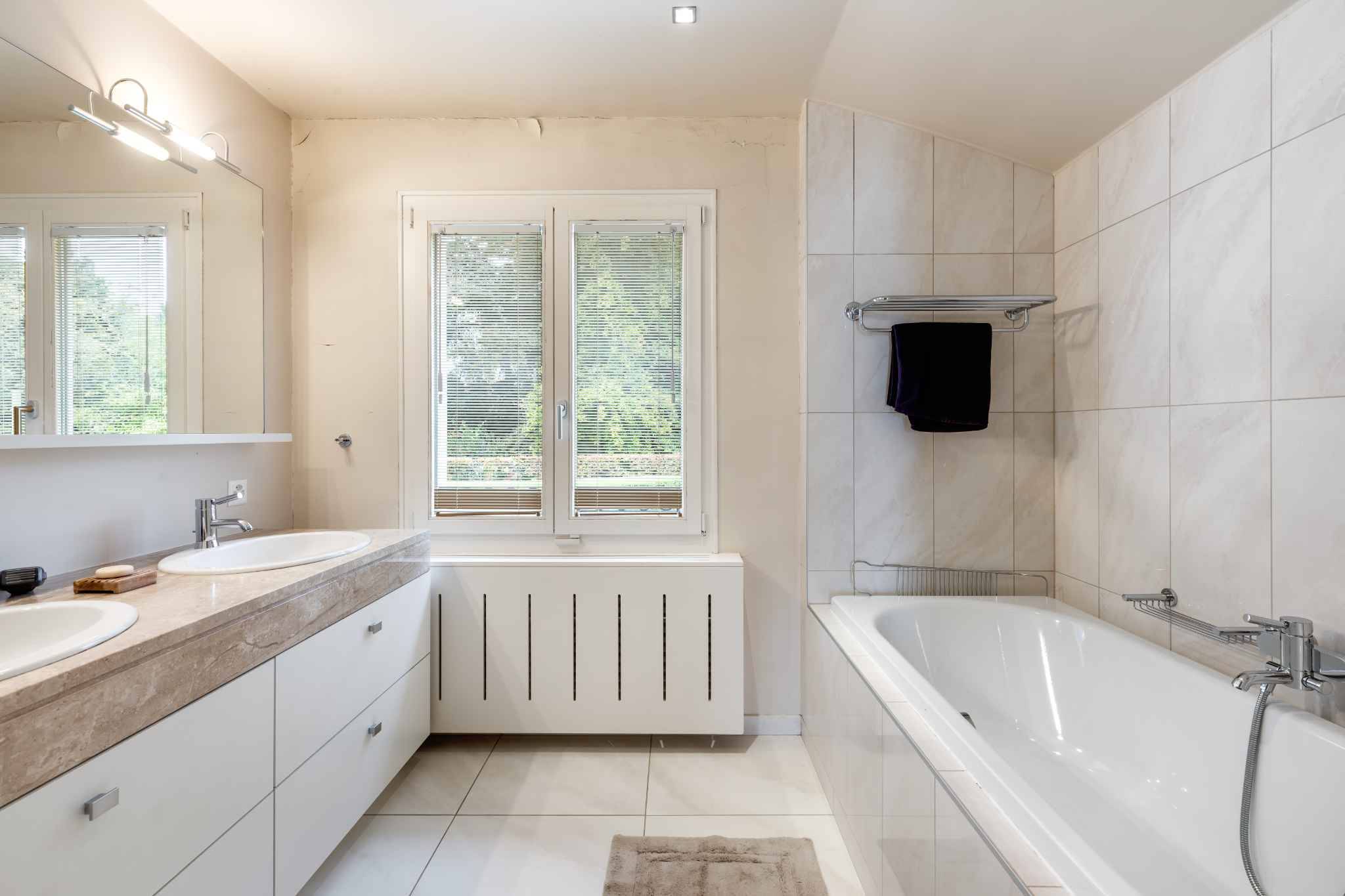 Helles Badezimmer mit Badewanne und Doppelwaschtisch