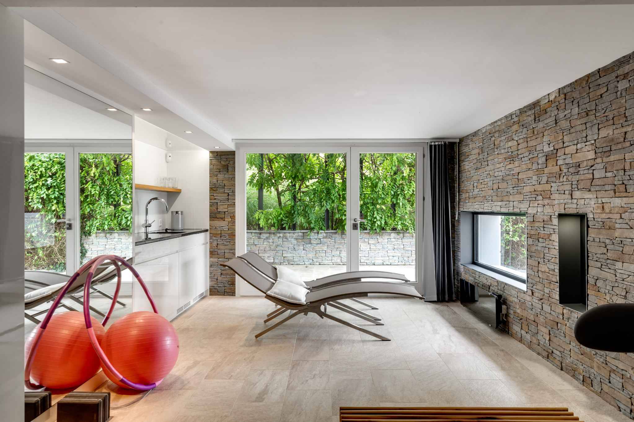 Moderner Wellnessraum mit Liegen und Glasfront