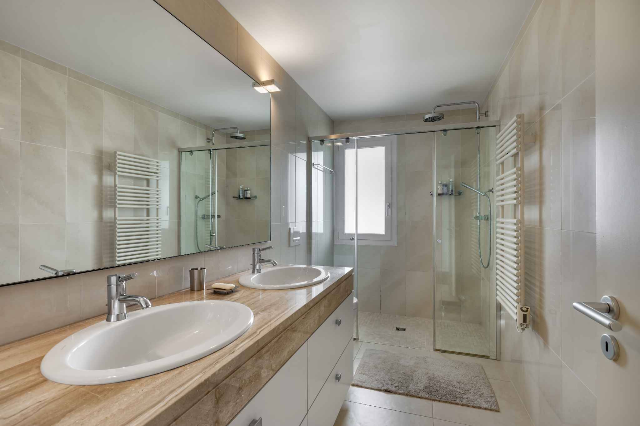 Helles modernes Badezimmer mit Doppelwaschtisch und Glasdusche