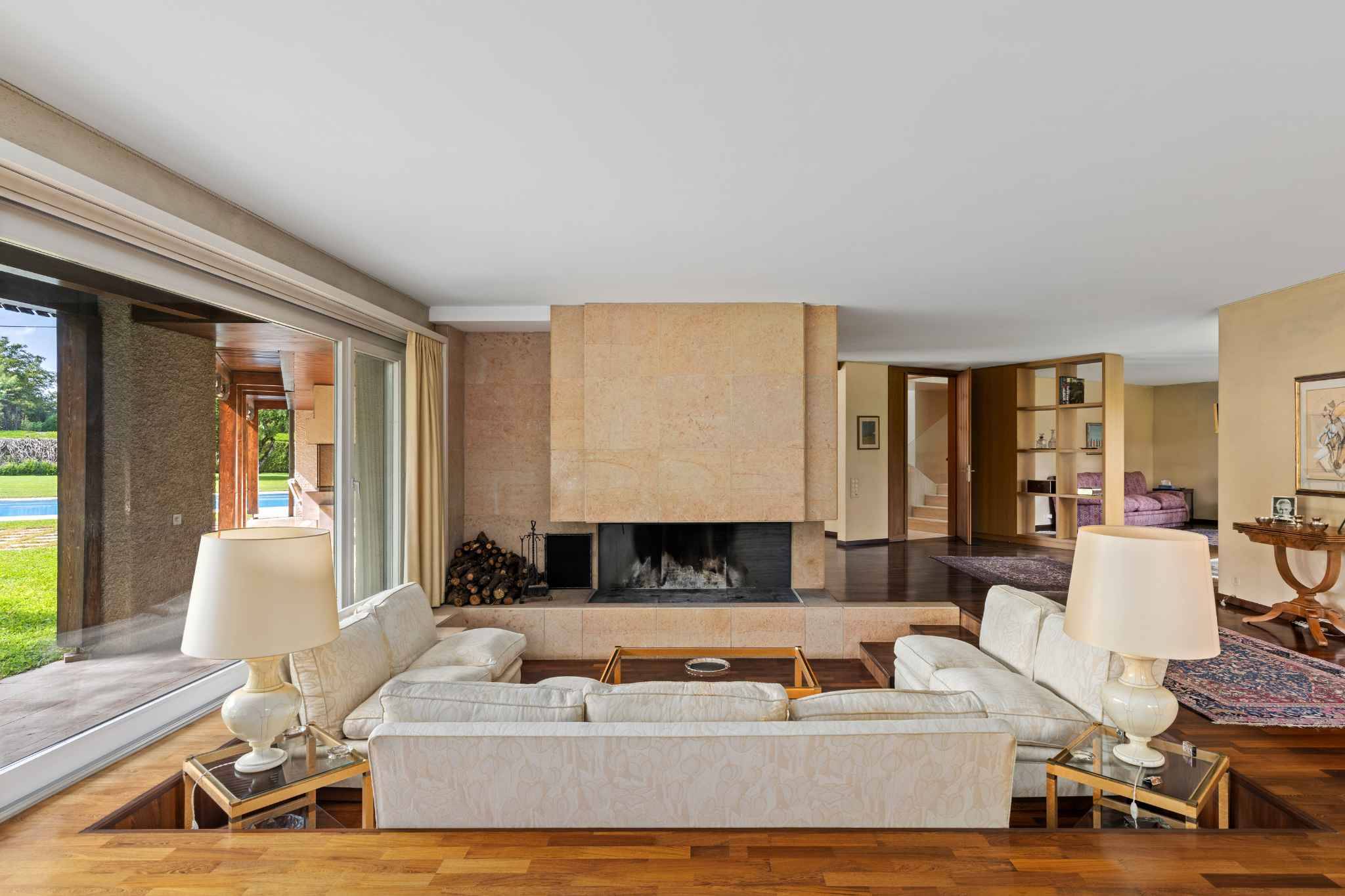 Wohnzimmer mit Kamin und großer Fensterfront