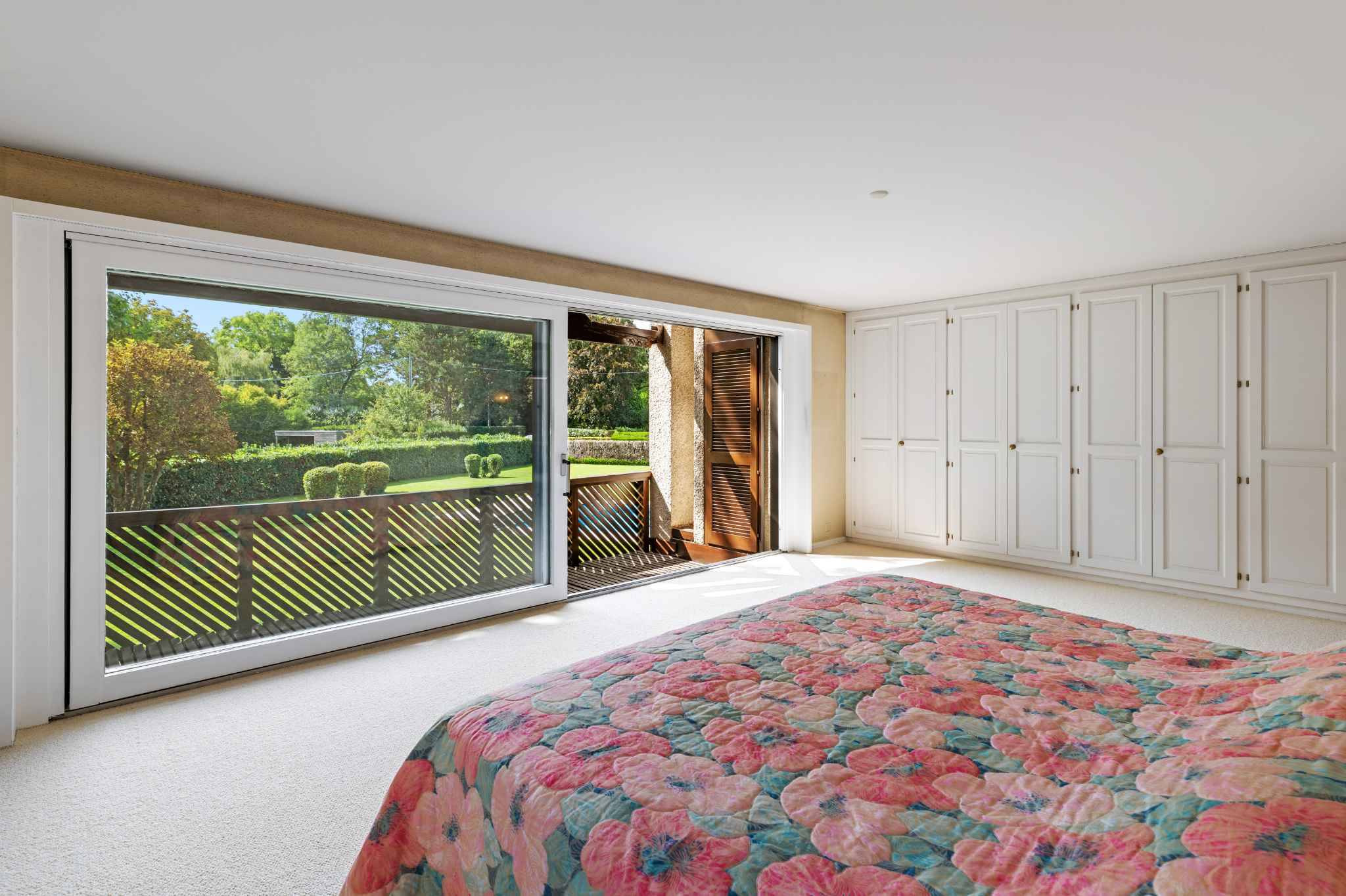 Helles Schlafzimmer mit Balkonblick und Einbauschränken
