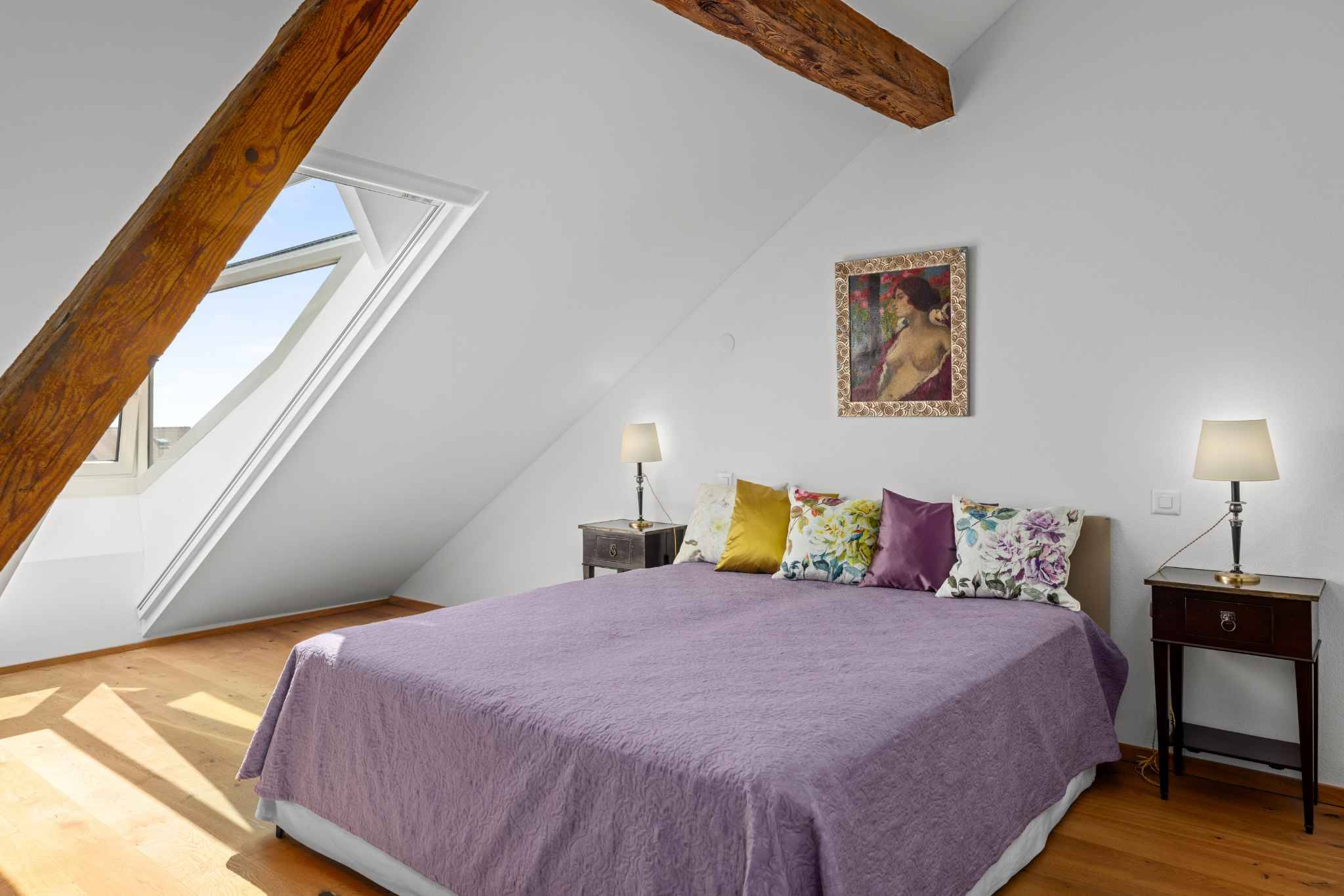 Helles Schlafzimmer mit Dachschräge und Sichtbalken