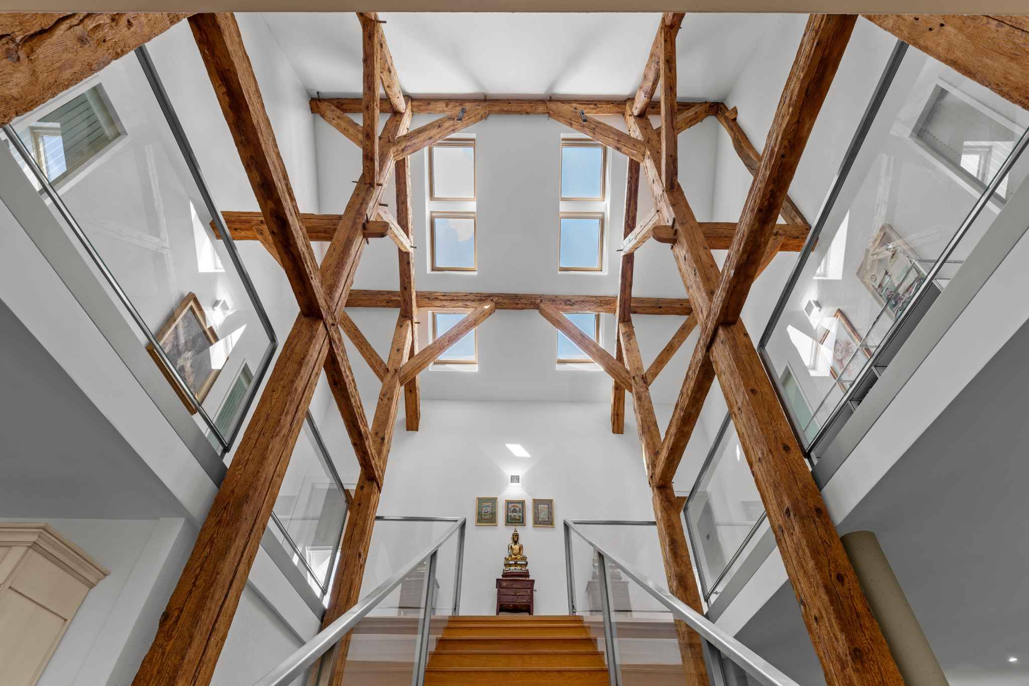 Lichtdurchflutetes Treppenhaus mit sichtbarem Holztragwerk