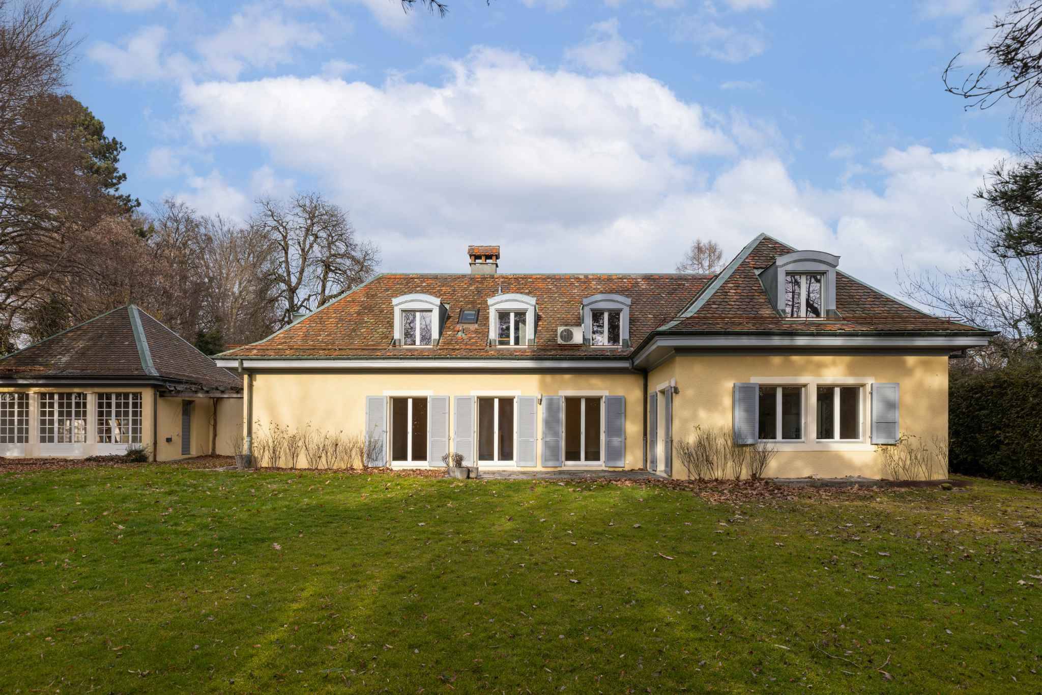 Außenansicht eines Landhauses mit Mansarddach