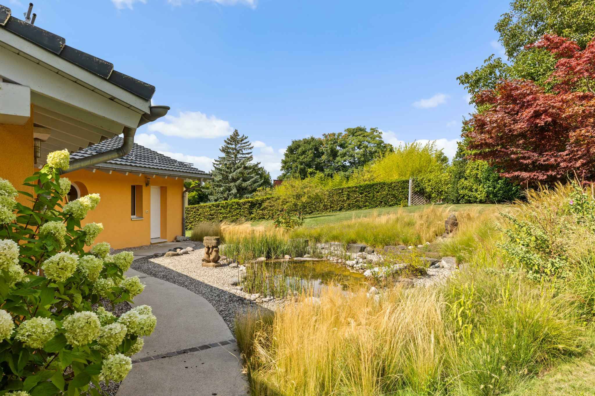 Gartenansicht mit Teich und Wohnhaus