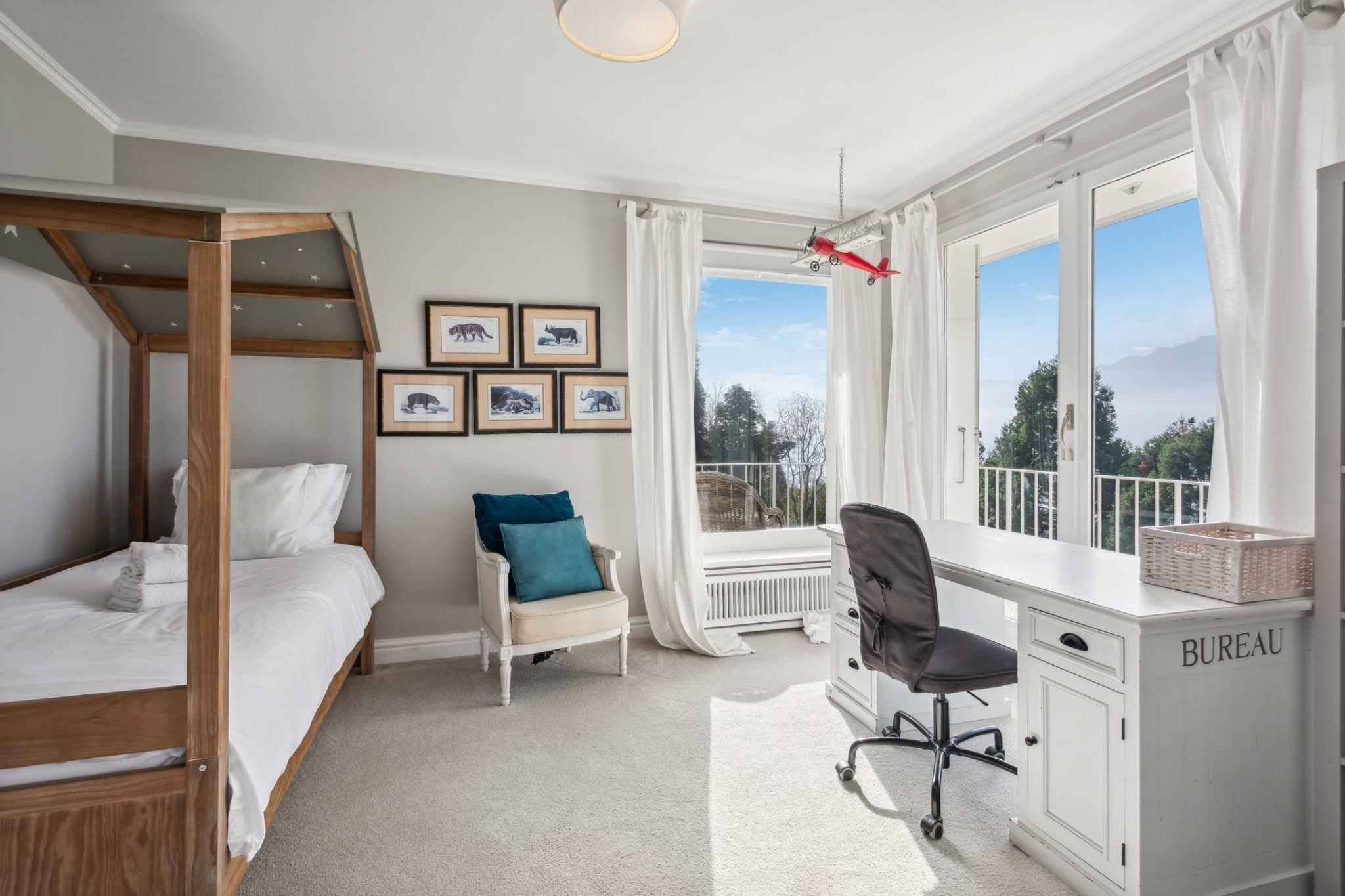 Helles Schlafzimmer mit Arbeitsplatz und Bergblick