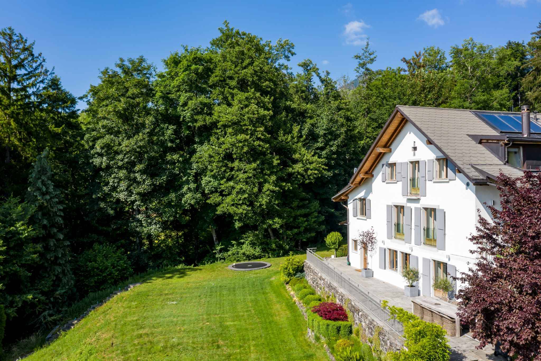 Haus mit großzügigem Garten und Waldkulisse