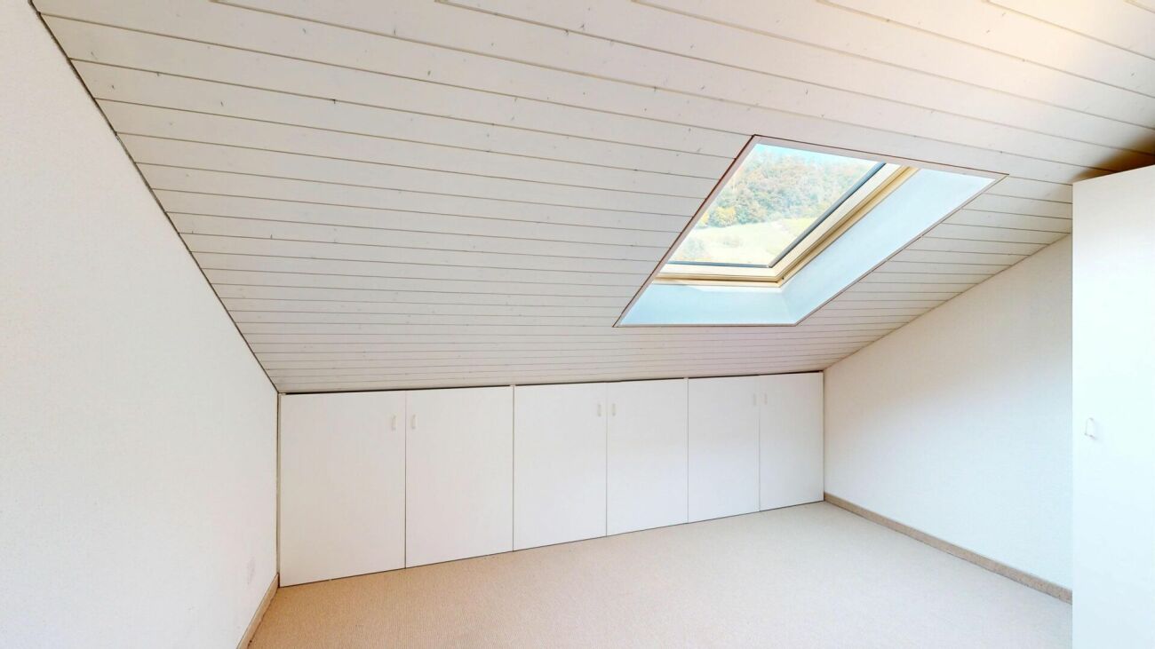 Dachzimmer mit Dachfenster und Einbauschränken