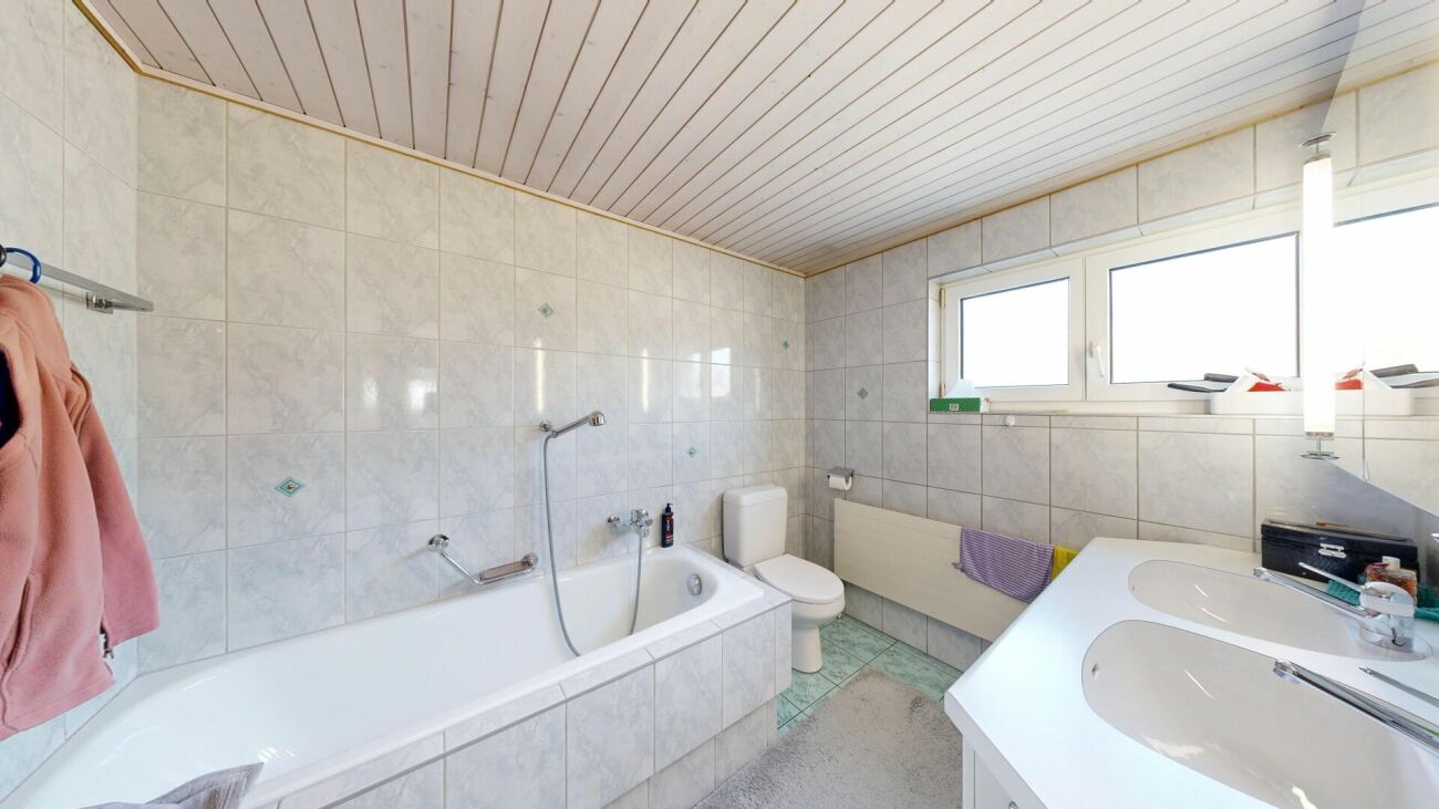 Helles Badezimmer mit Badewanne und Doppelwaschtisch