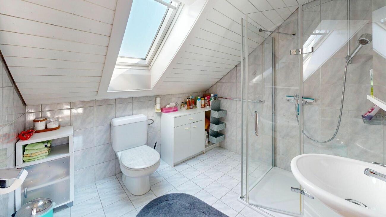 Badezimmer unter Dachschräge mit Dusche und WC