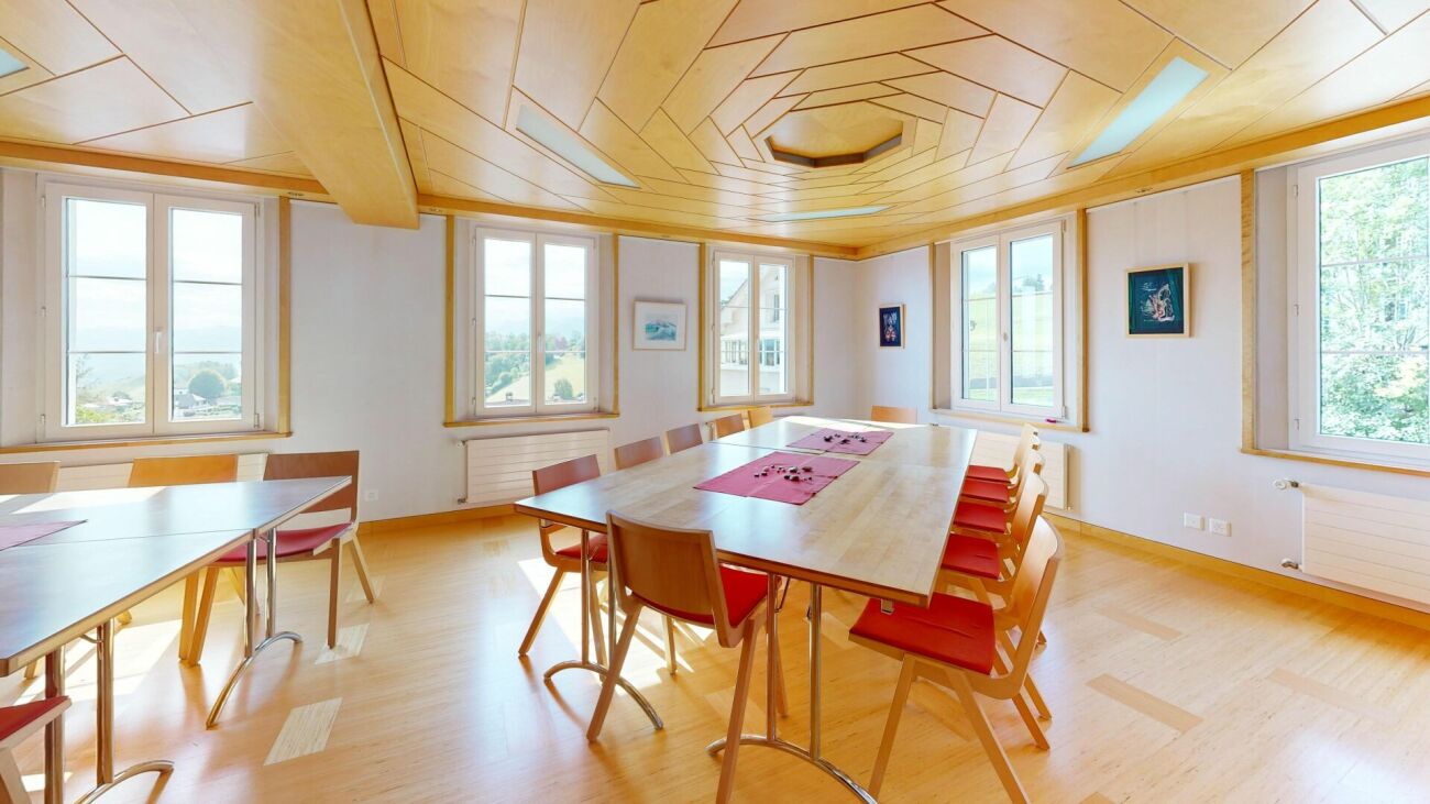Heller Ess-/Konferenzraum mit besonderer Holzdecke