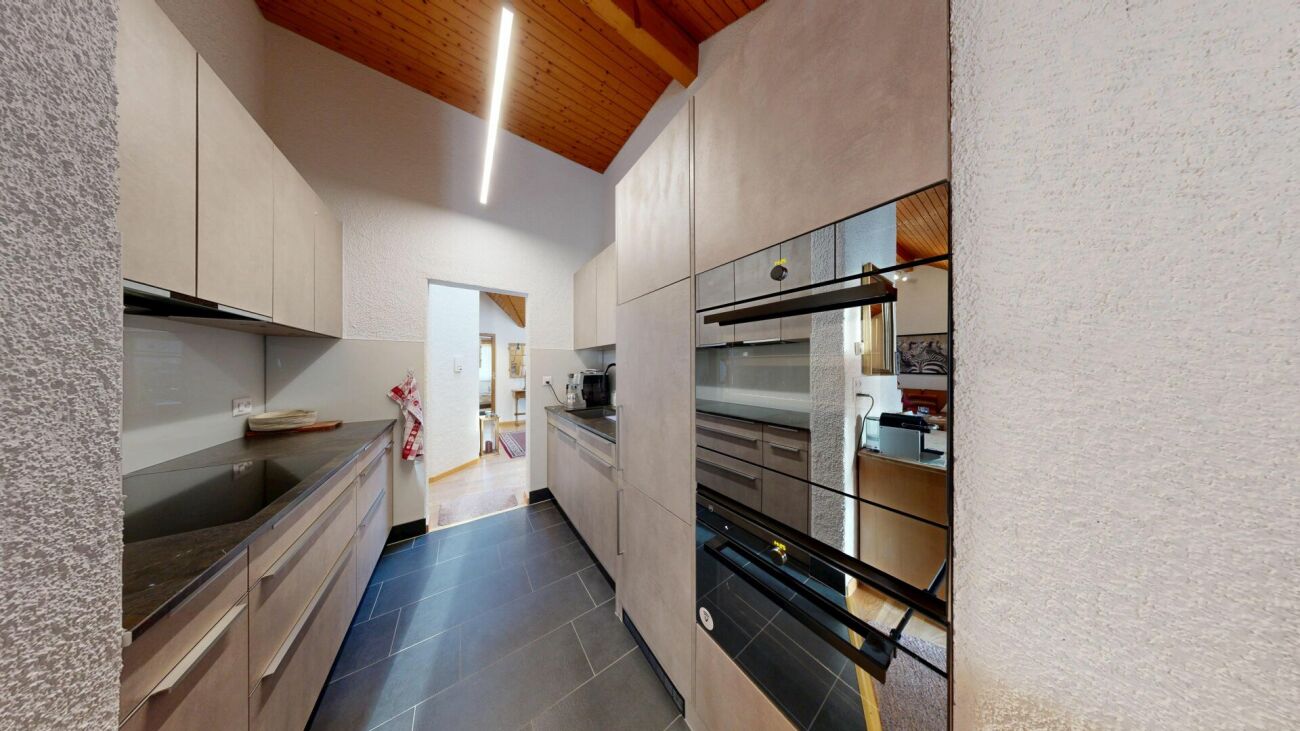 Moderne schmale Küche mit Holzdecke