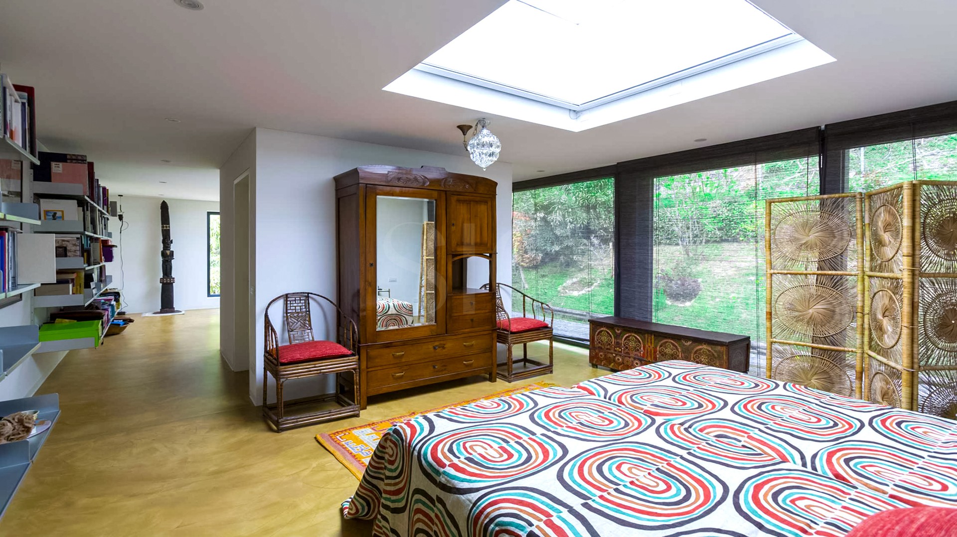 Helles Schlafzimmer mit Dachfenster und großen Fensterflächen