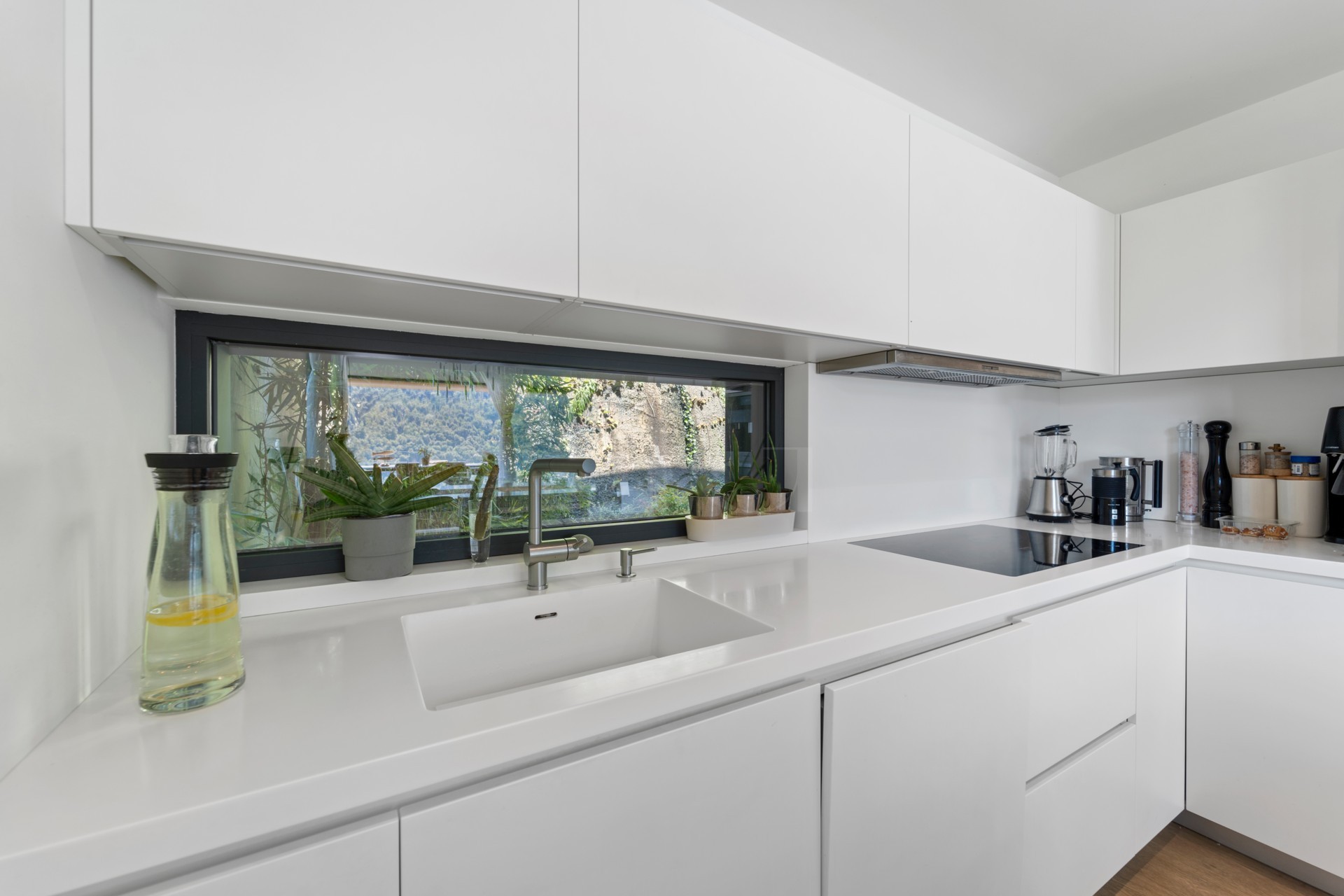 Moderne weiße Küche mit Fensterfront