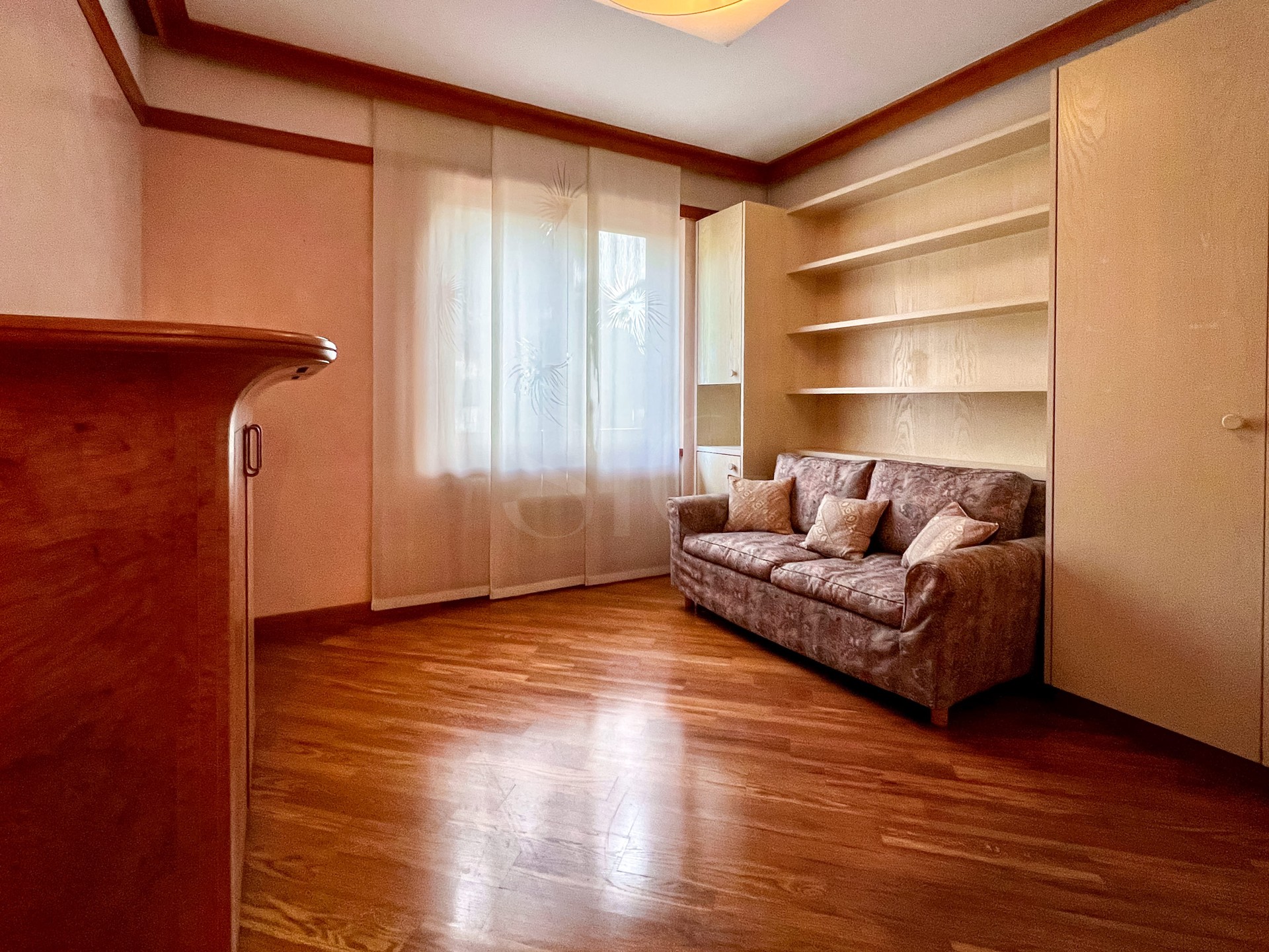 Helles Wohnzimmer mit Sofa und Einbauregalen