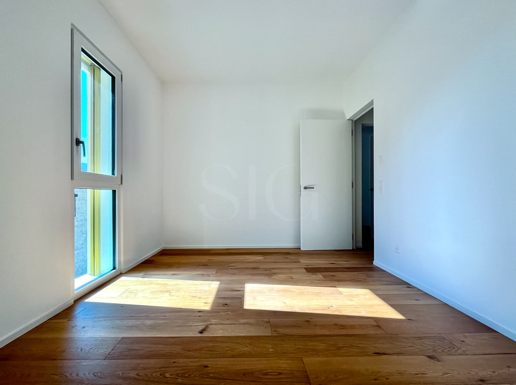 Helles, leeres Zimmer mit Holzfußboden
