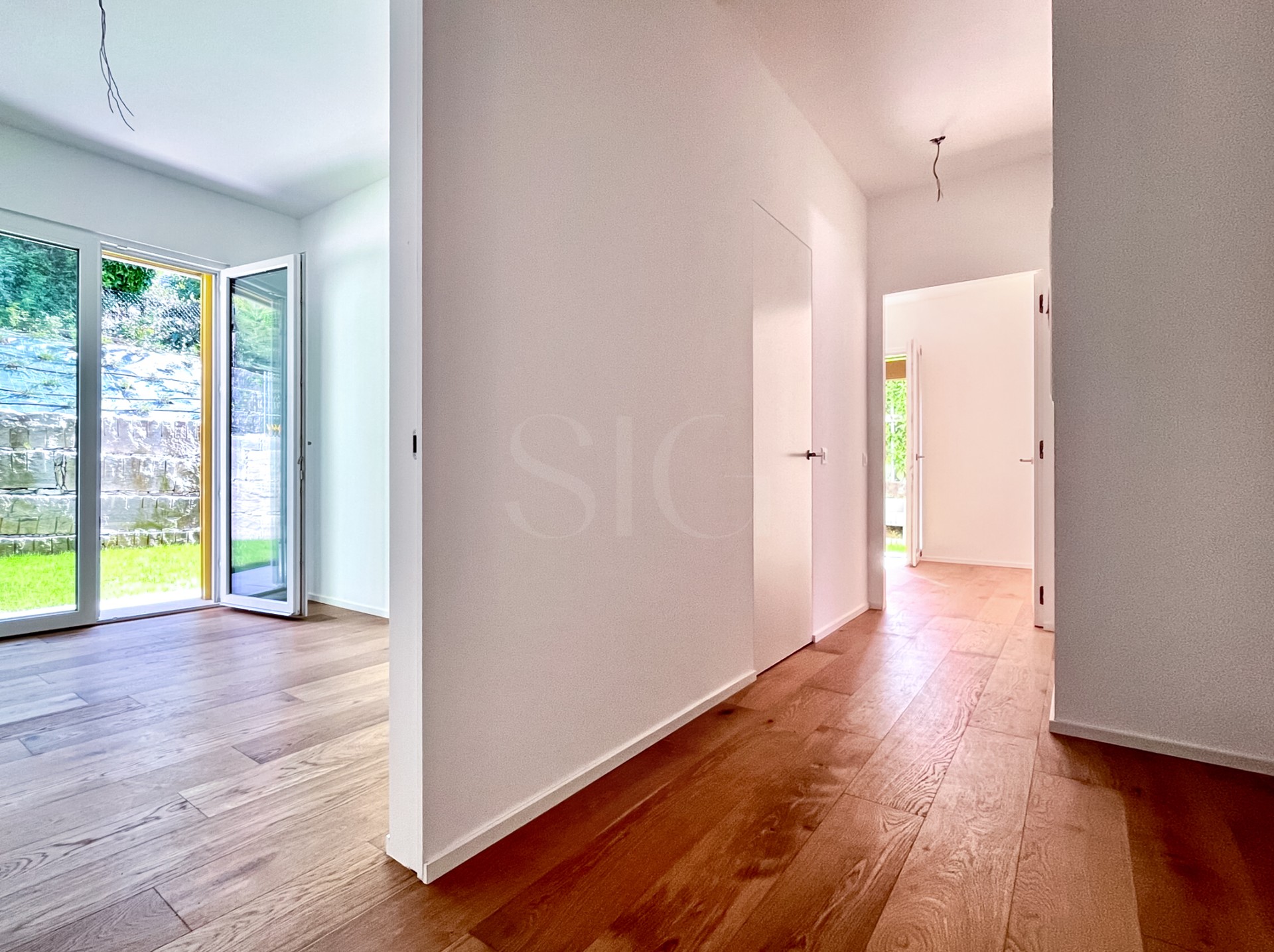 Heller Flur mit Blick in einen Wohnraum