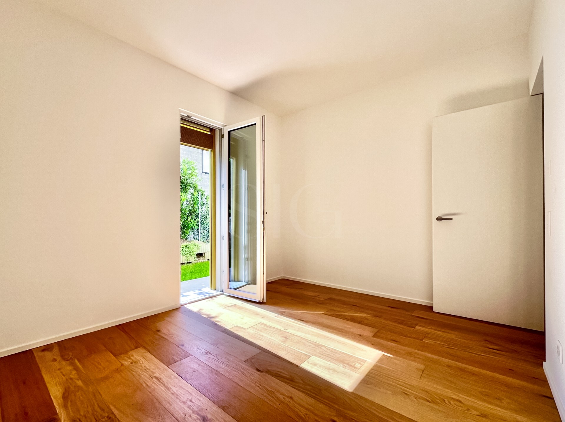 Leeres, helles Zimmer mit Terrassentür