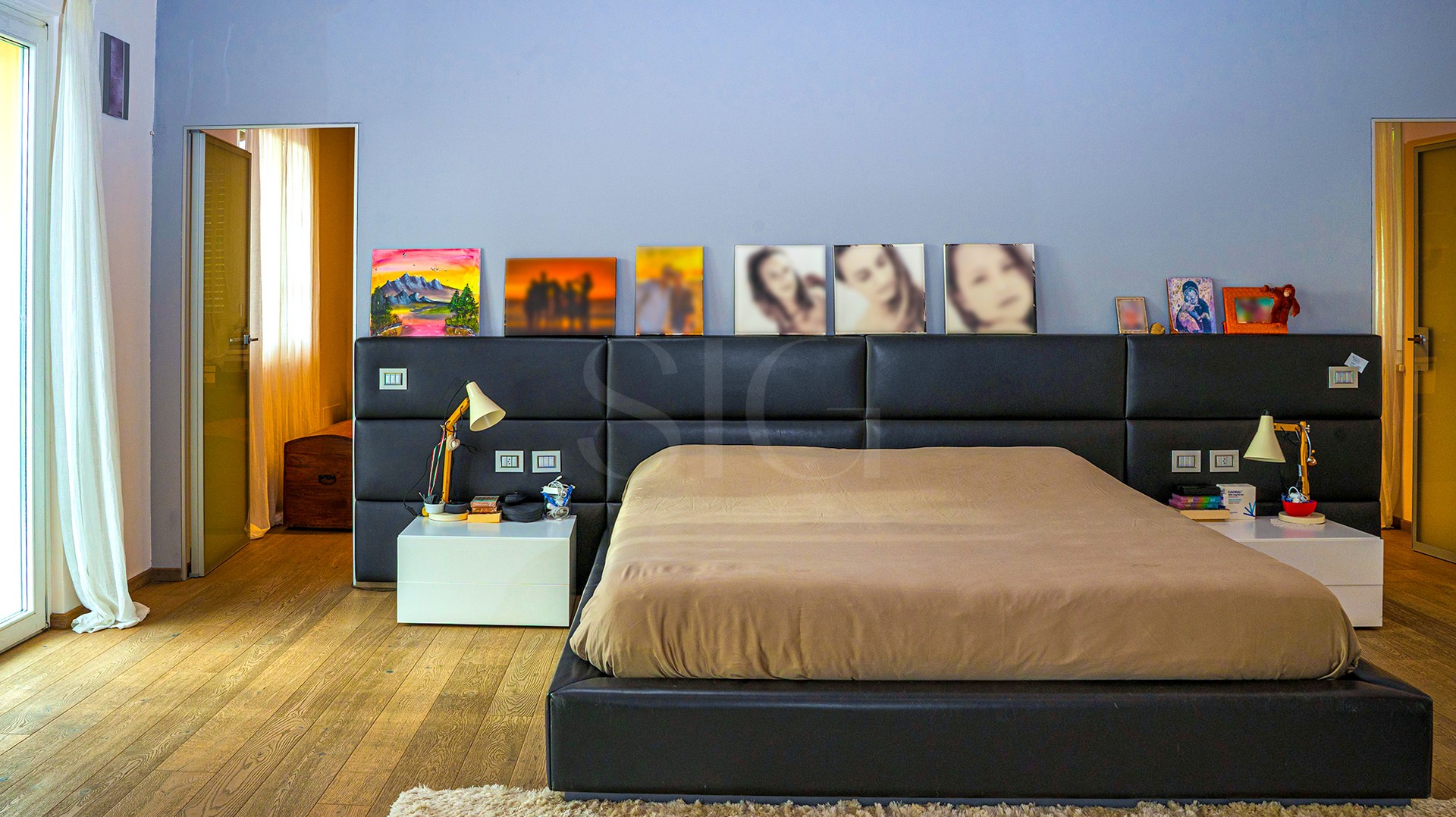 Schlafzimmer mit großem Bett und dunklem Kopfteil