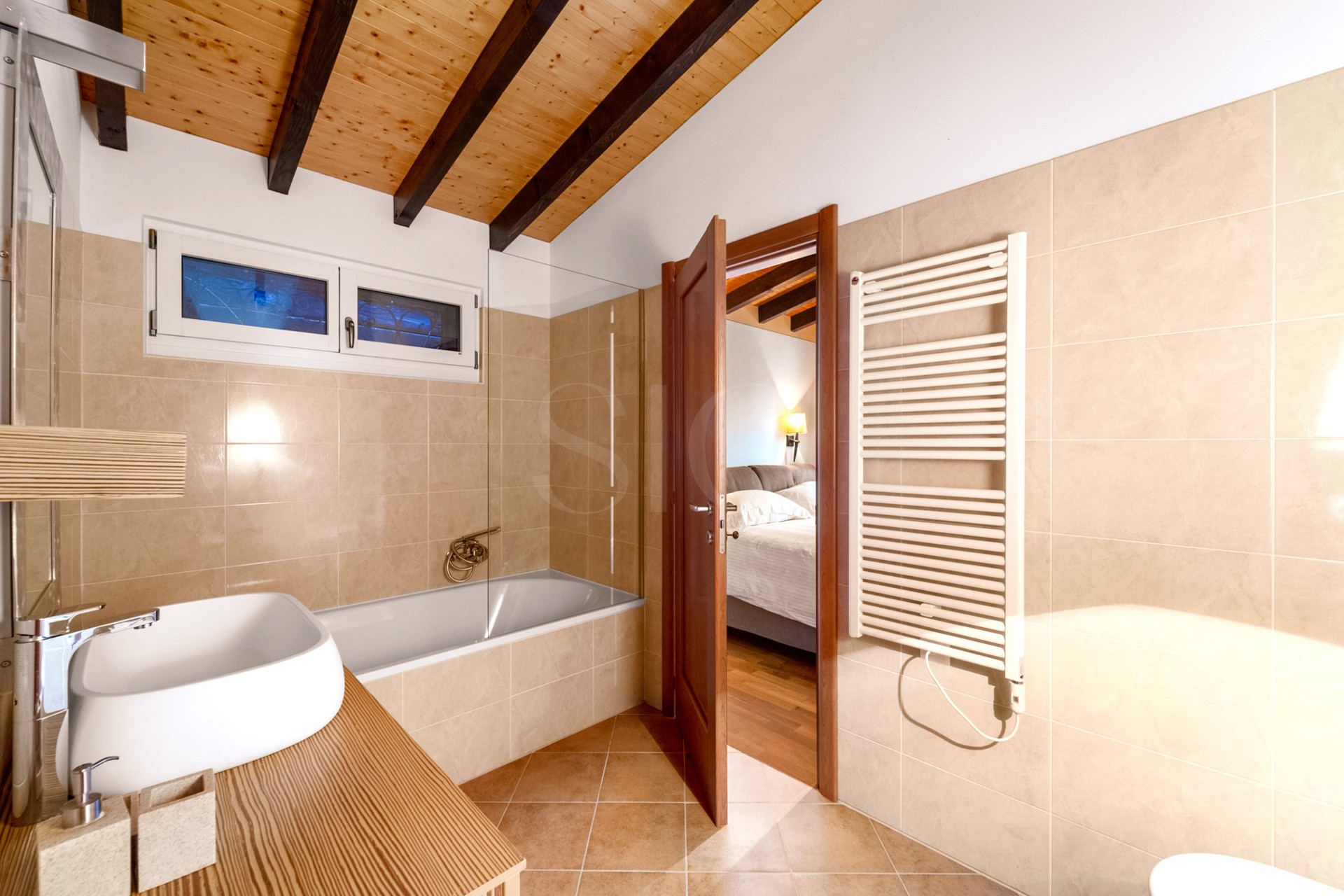 Helles Badezimmer mit Holzdecke und Badewanne