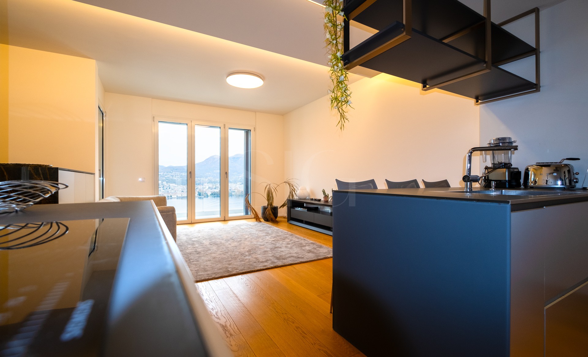 Moderne offene Wohnküche mit Seeblick