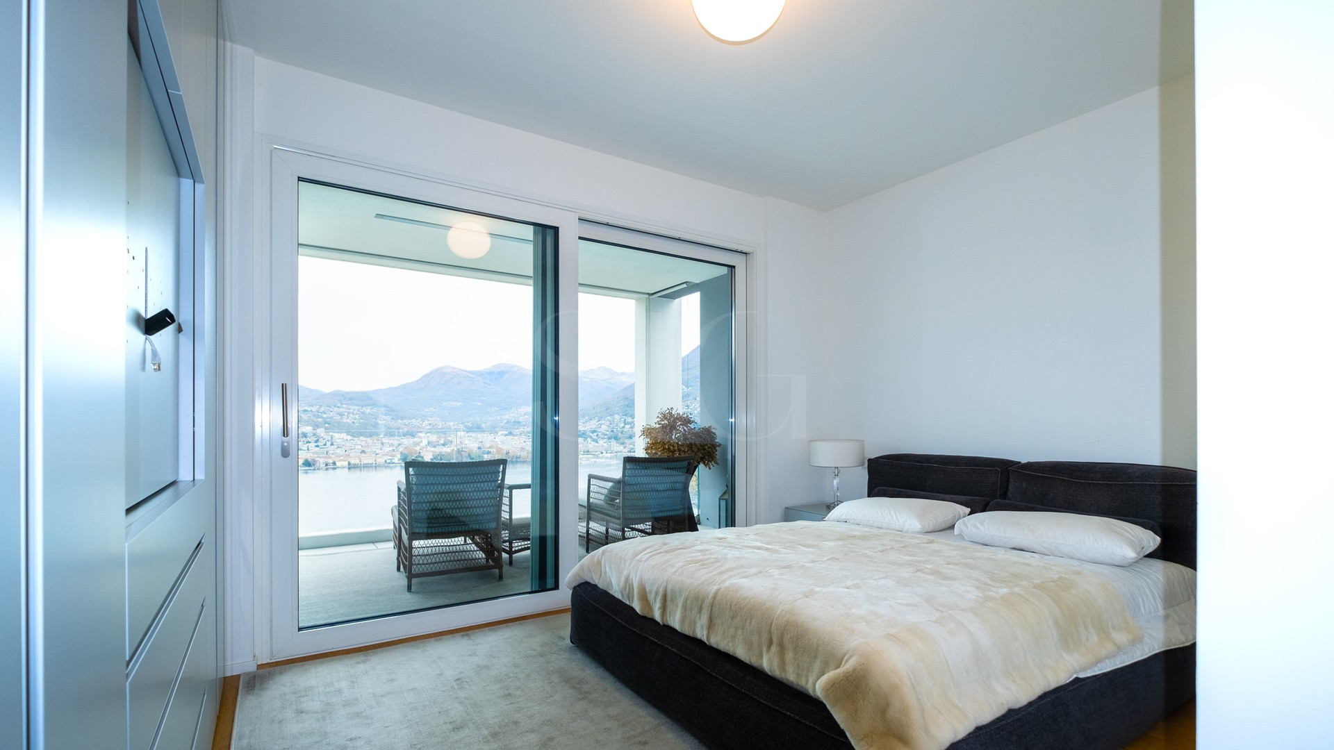 Schlafzimmer mit Balkon- und Seeblick