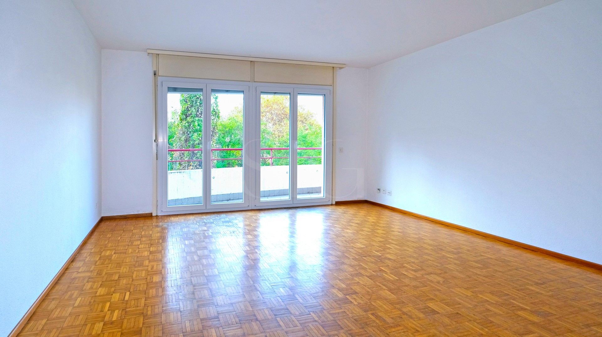 Leerer Wohnraum mit Balkonzugang