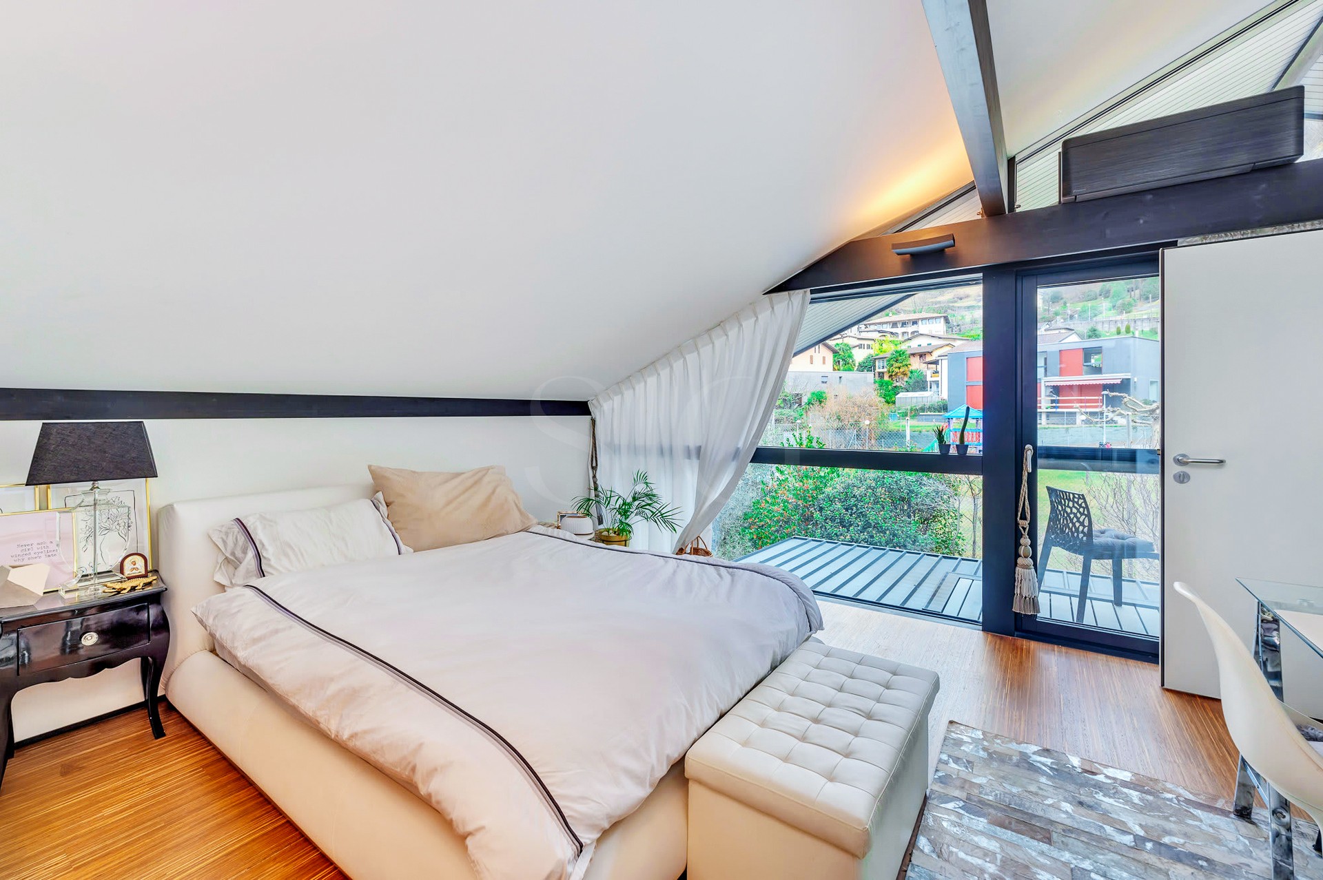 Schlafzimmer mit Dachschräge und Balkonblick