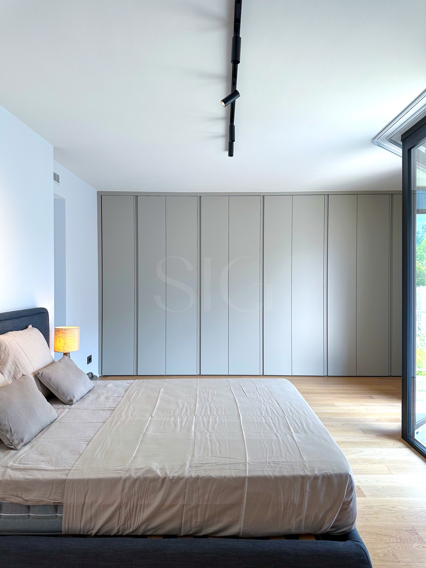 Modernes Schlafzimmer mit Einbauschrank und bodentiefer Verglasung